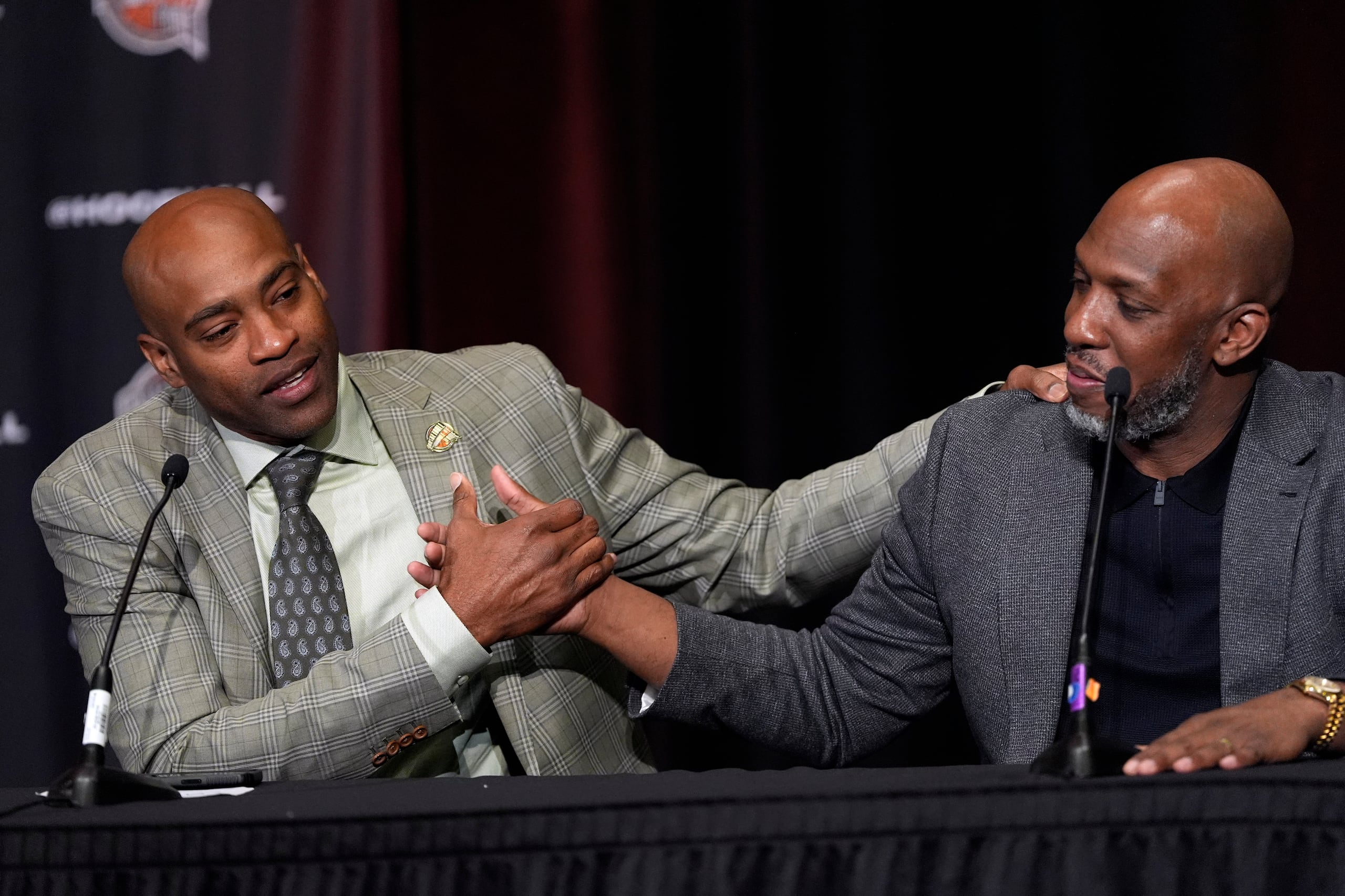 Vince Carter (izquierda) y Chauncey Billups se dan la mano durante una conferencia tras ser elegidos miembros del Salón de la Fama, el sábado 6 de abril de 2024, en Phoenix (AP Foto/David J. Phillip)