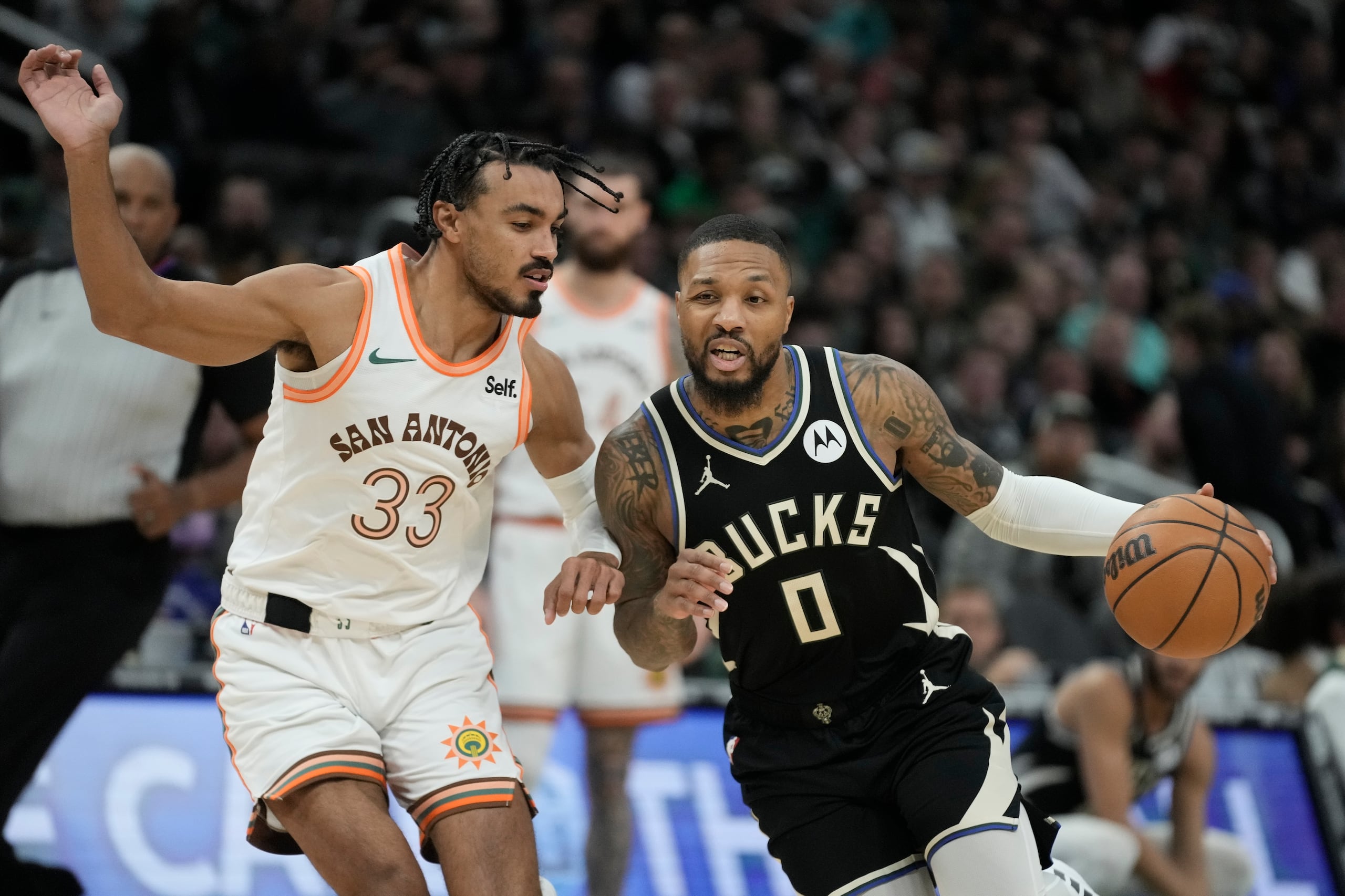 Damian Lillard, de los Bucks de Milwaukee, elude a Tre Jones, de los Spurs de San Antonio, en el encuentro del martes 19 de diciembre de 2023 (AP Foto/Morry Gash)