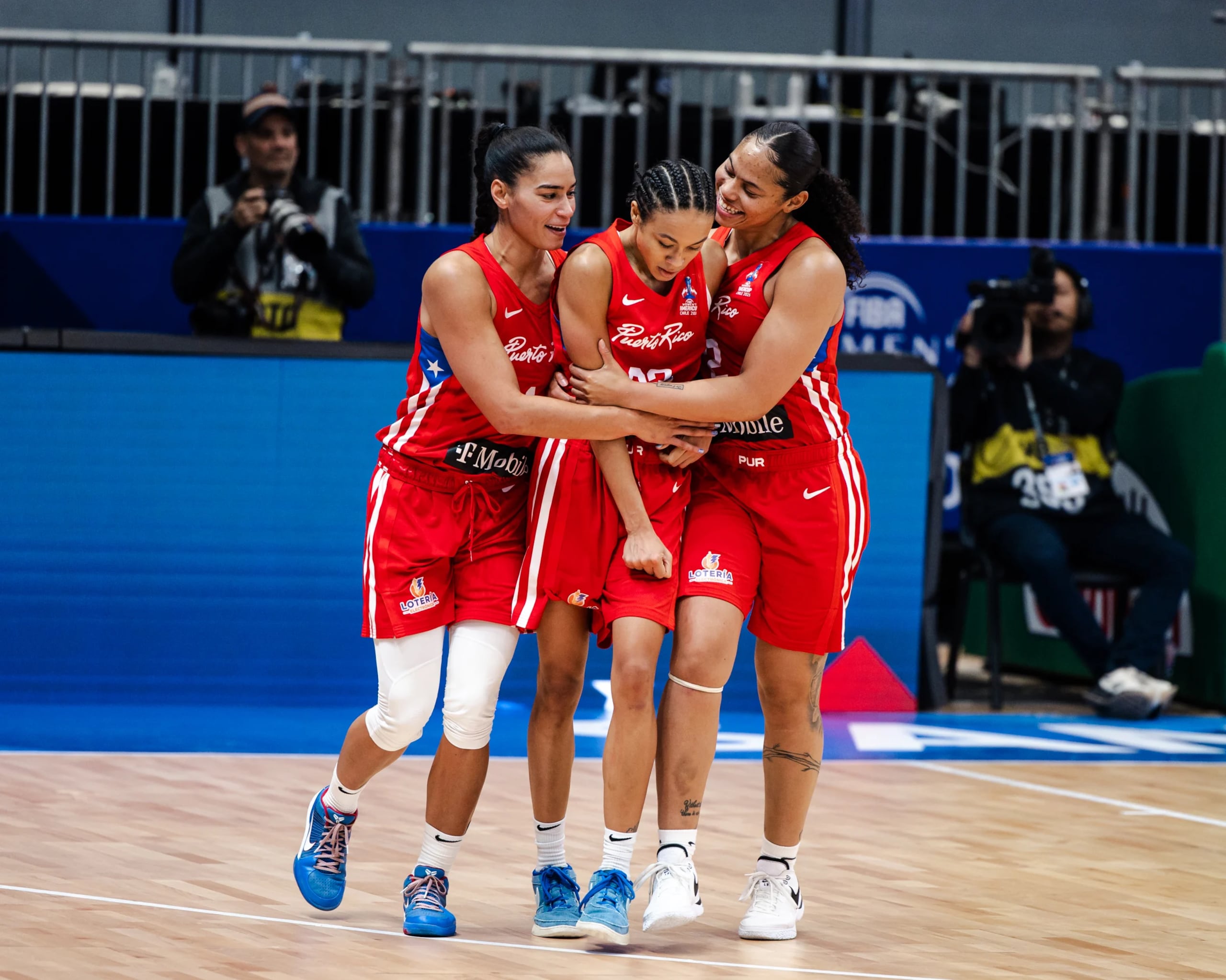 Tayra Meléndez y Brianna Jones abrazan a Trinity San Antonio después de anotar un canasto.