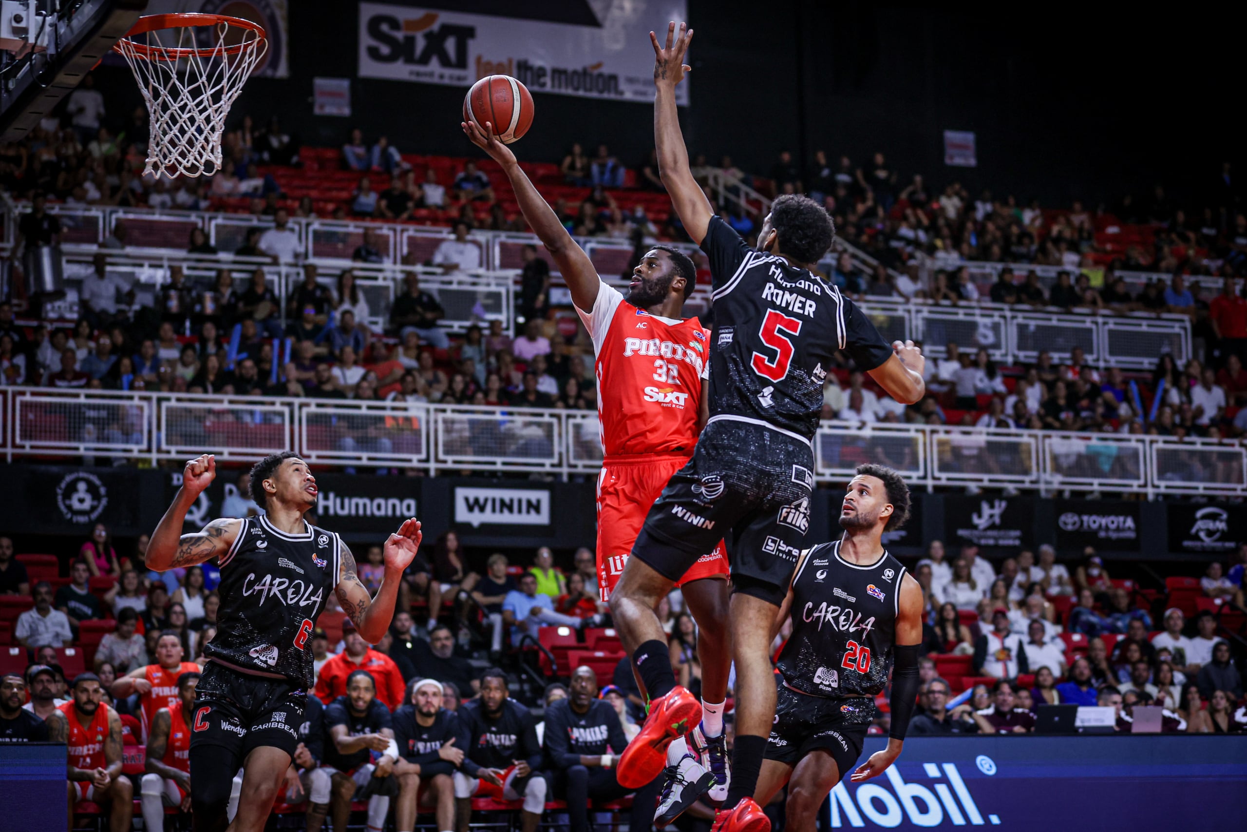 Emmanuel Mudiay, de los Piratas de Quebradillas, ataca el canasto ante la defensa de los Gigantes de Carolina.