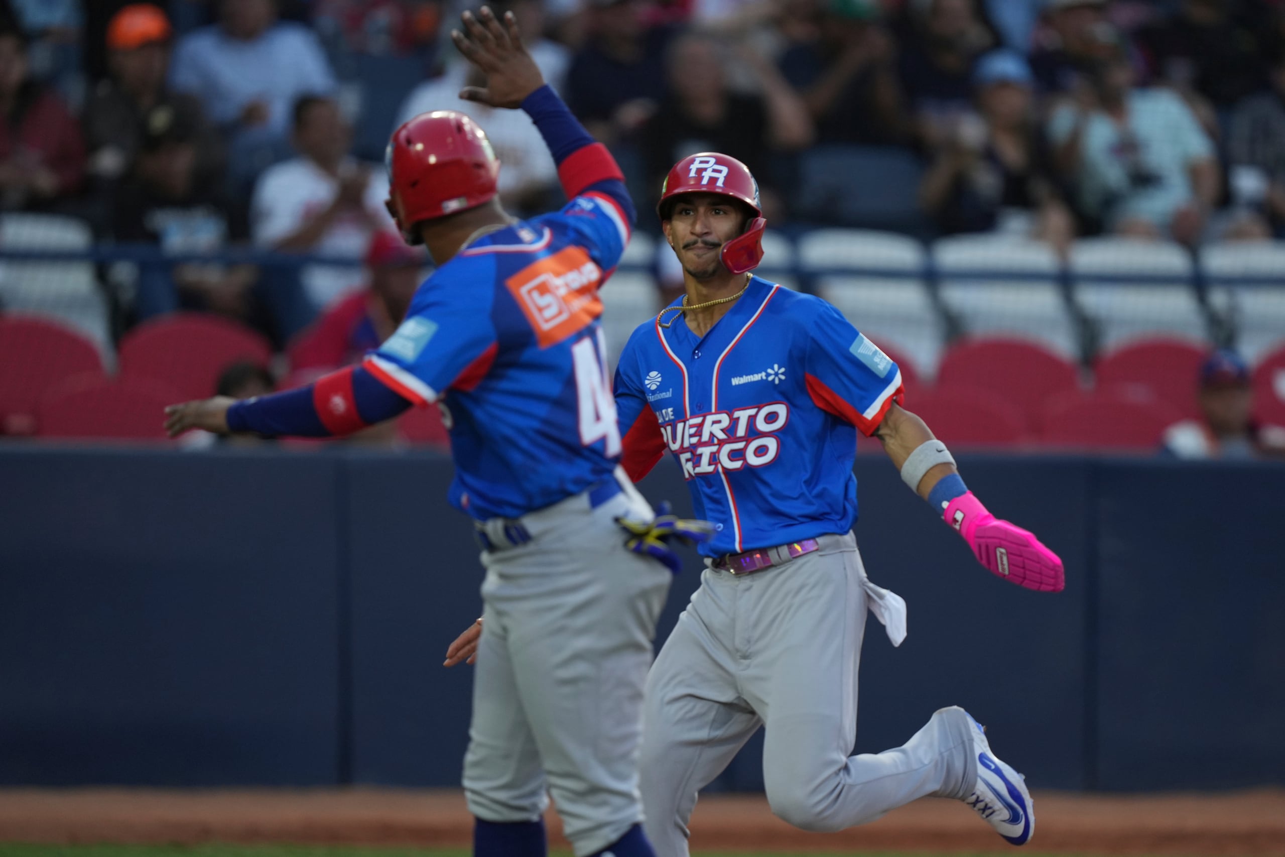 Robbie Merced, a la derecha, de Puerto Rico, festeja tras anotar ante República Dominicana en la Serie del Caribe. Su corrido fue desde primera base con un hit de Eddie Rosario que puso a los Indios en ventaja 8-7 en la octava entrada.