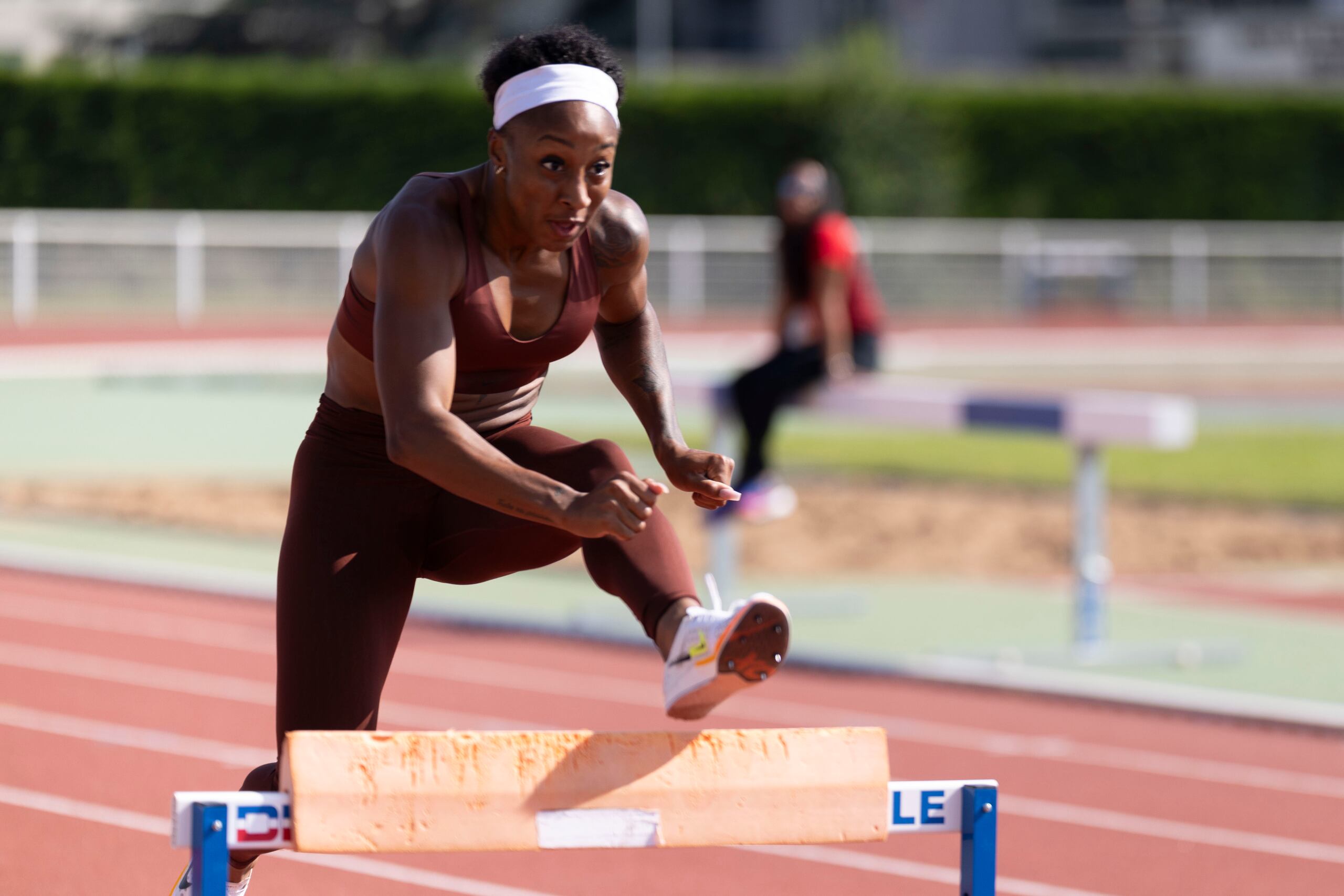 La boricua Jasmine Camacho Quinn salta una valla con un aparato que la hace estar más alta de la medida oficial de la competencia.