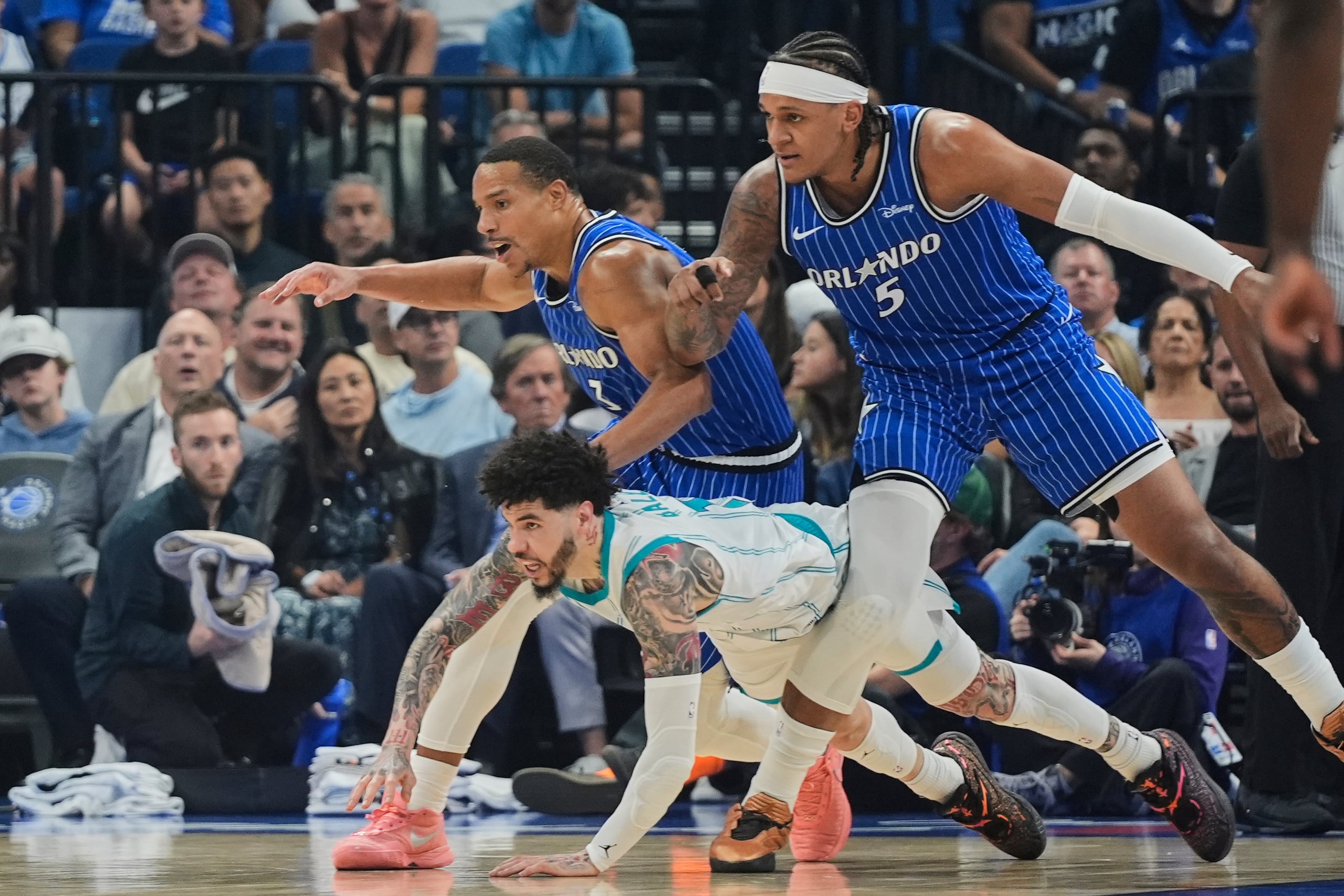 LaMelo Ball, al centro; Desmond Bane y Paolo Banchero luchan por el balón durante un juego entre el Magic de Orlando y los Hornets de Charlotte.
