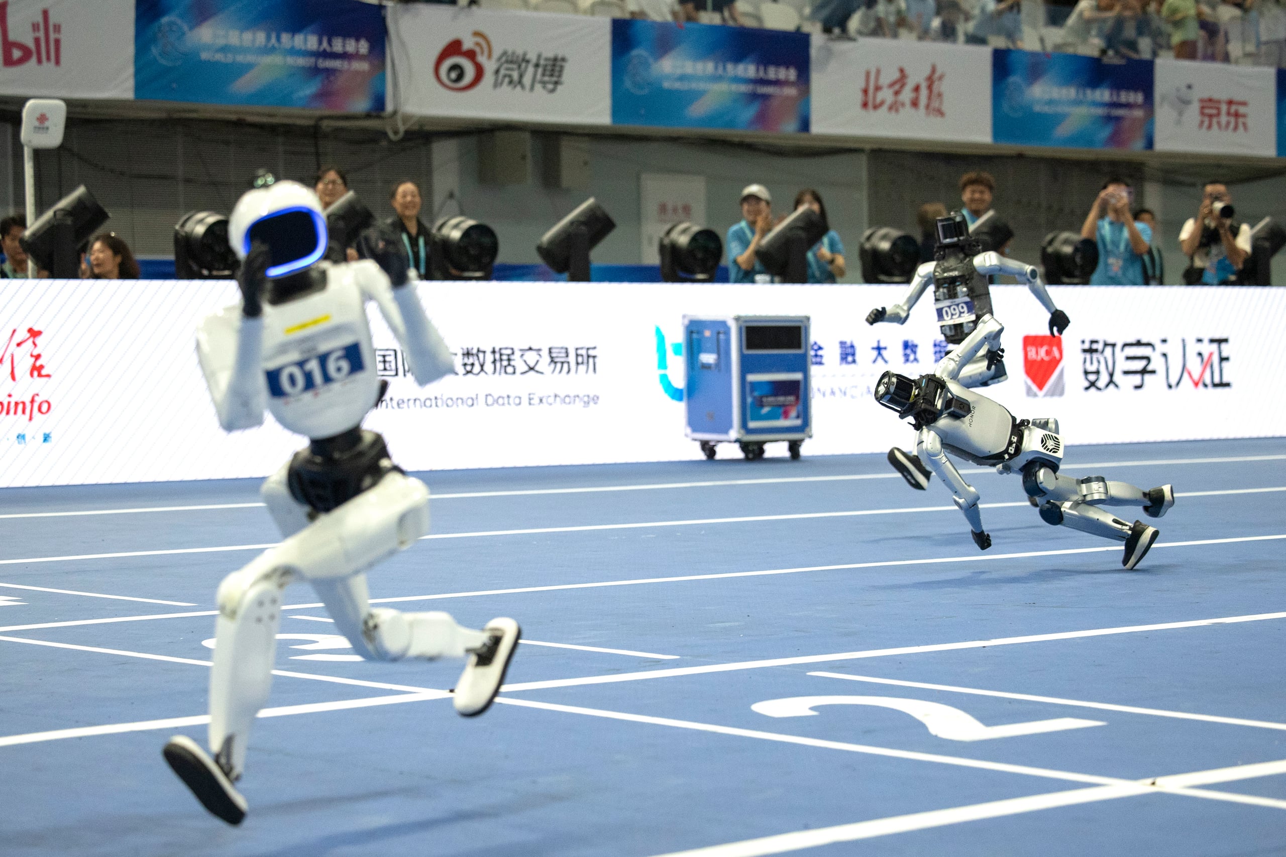 Robots humanoides durante la prueba de grandes robots 400m en los Juegos Mundiales de Robots Humanoides que se celebran en Pekín, este domingo.