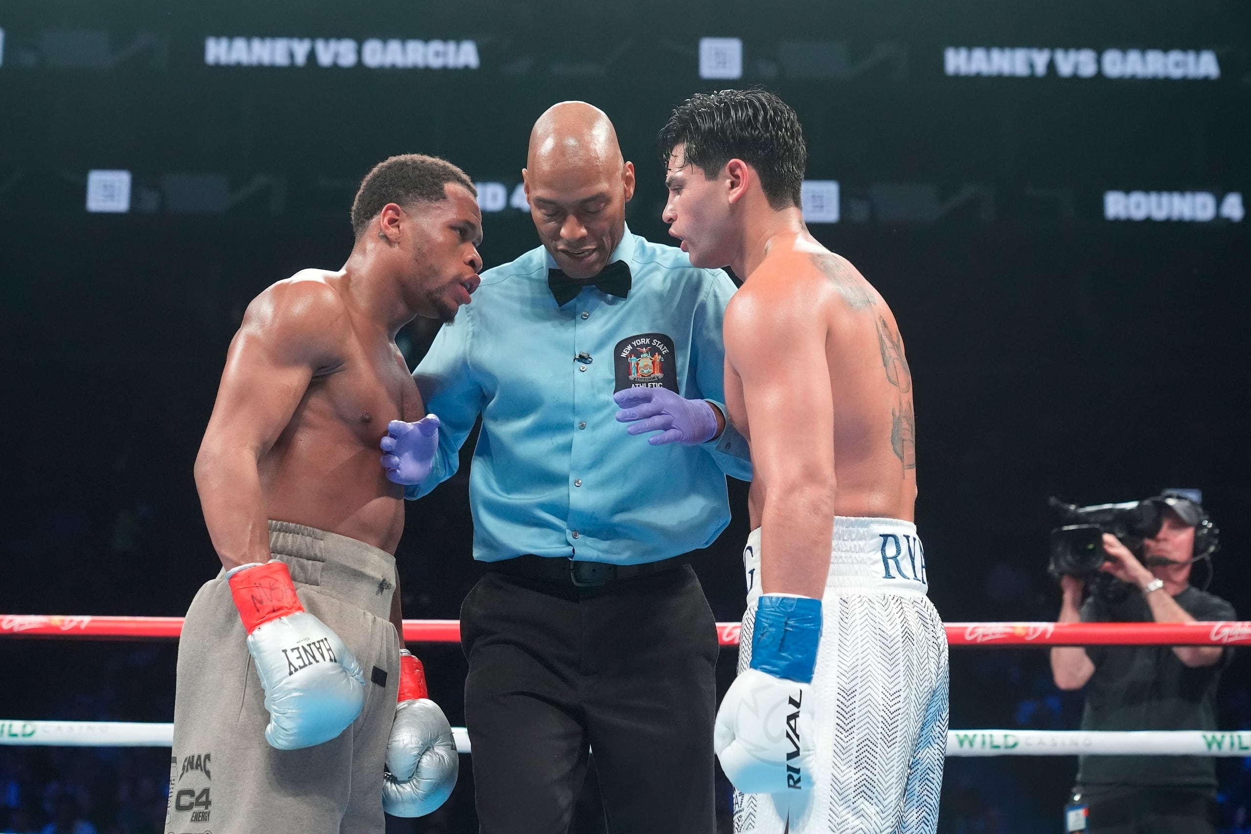 El réferi habla con Devin Haney (izquierda) y Ryan García durante su pelea por el título de los superligeros, el domingo 21 de abril de 2024, en Nueva York.