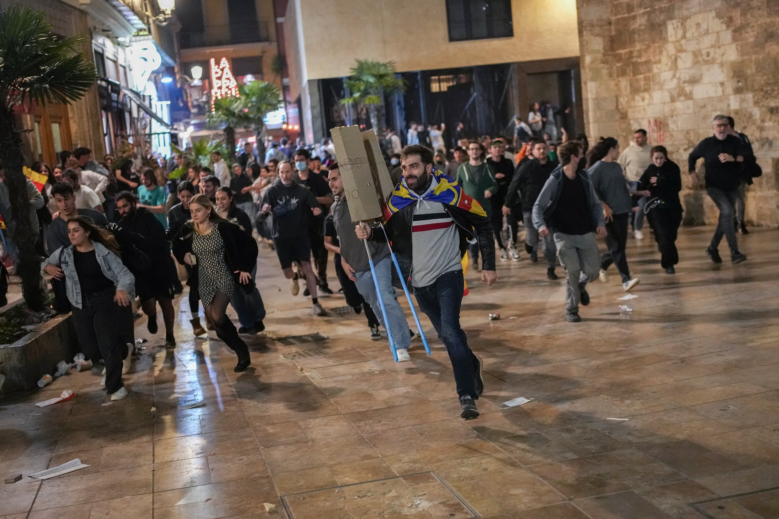 Manifestantes huyen de la Policía Antidisturbios durante pequeños enfrentamientos tras una protesta pacífica organizada por grupos sociales y cívicos, denunciando la gestión de las recientes inundaciones bajo el lema "Mazón, dimite", dirigido al presidente del gobierno regional Carlos Mazón, en Valencia, España, el sábado 9 de noviembre de 2024. (Foto AP/Emilio Morenatti)