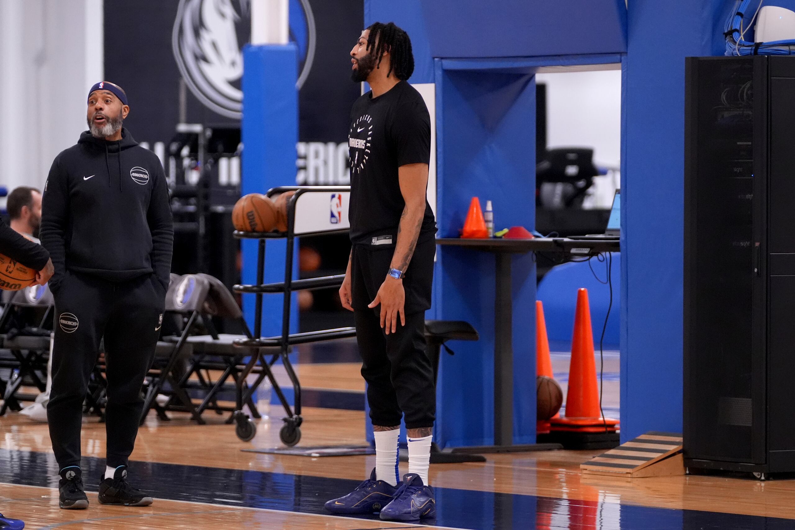 Anthony Davis, centro, de los Mavericks de Dallas, habla con el personal del equipo al final de la práctica de baloncesto de la NBA en las instalaciones de entrenamiento del equipo en Dallas.
