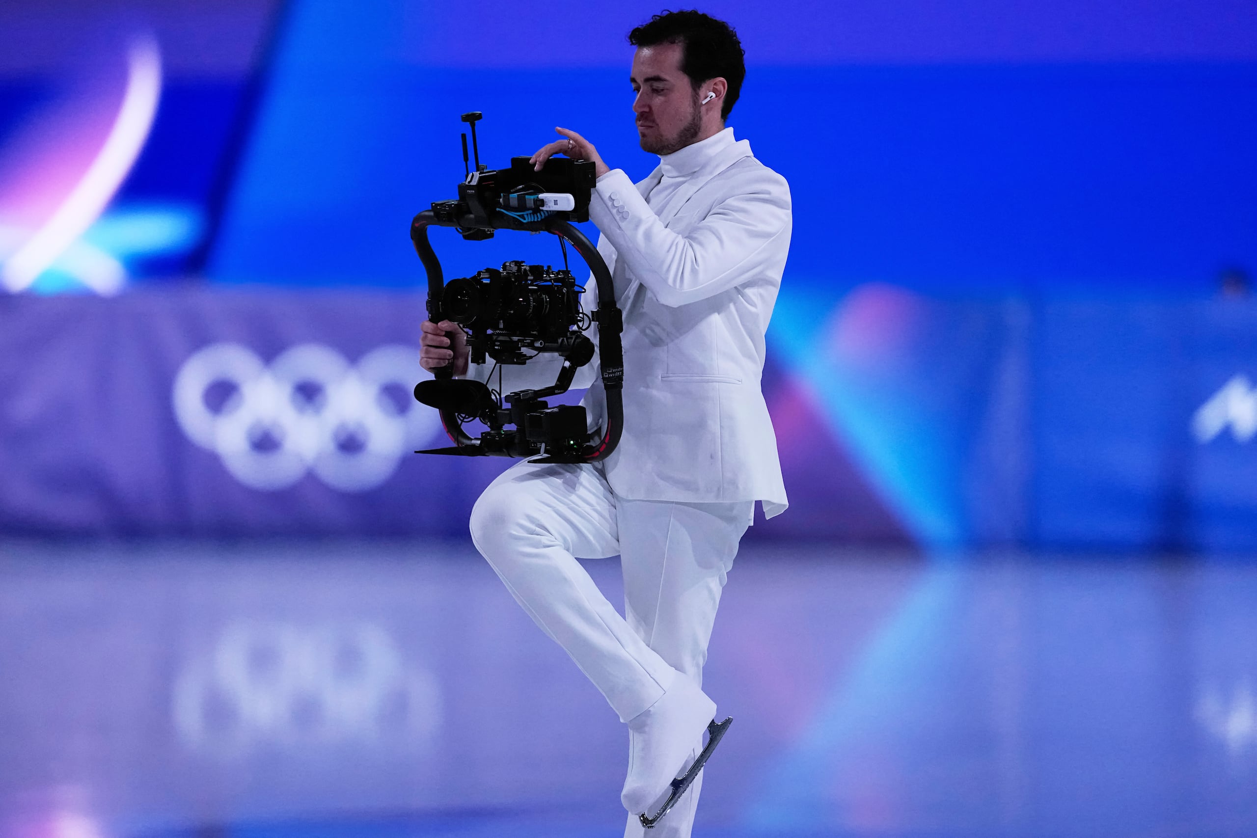Jordan Cowan opera su cámara antes del programa corto de patinaje artístico por parejas en los Juegos Olímpicos de Invierno de 2026, en Milán, Italia, el domingo 15 de febrero de 2026. (Foto AP/Ashley Landis)