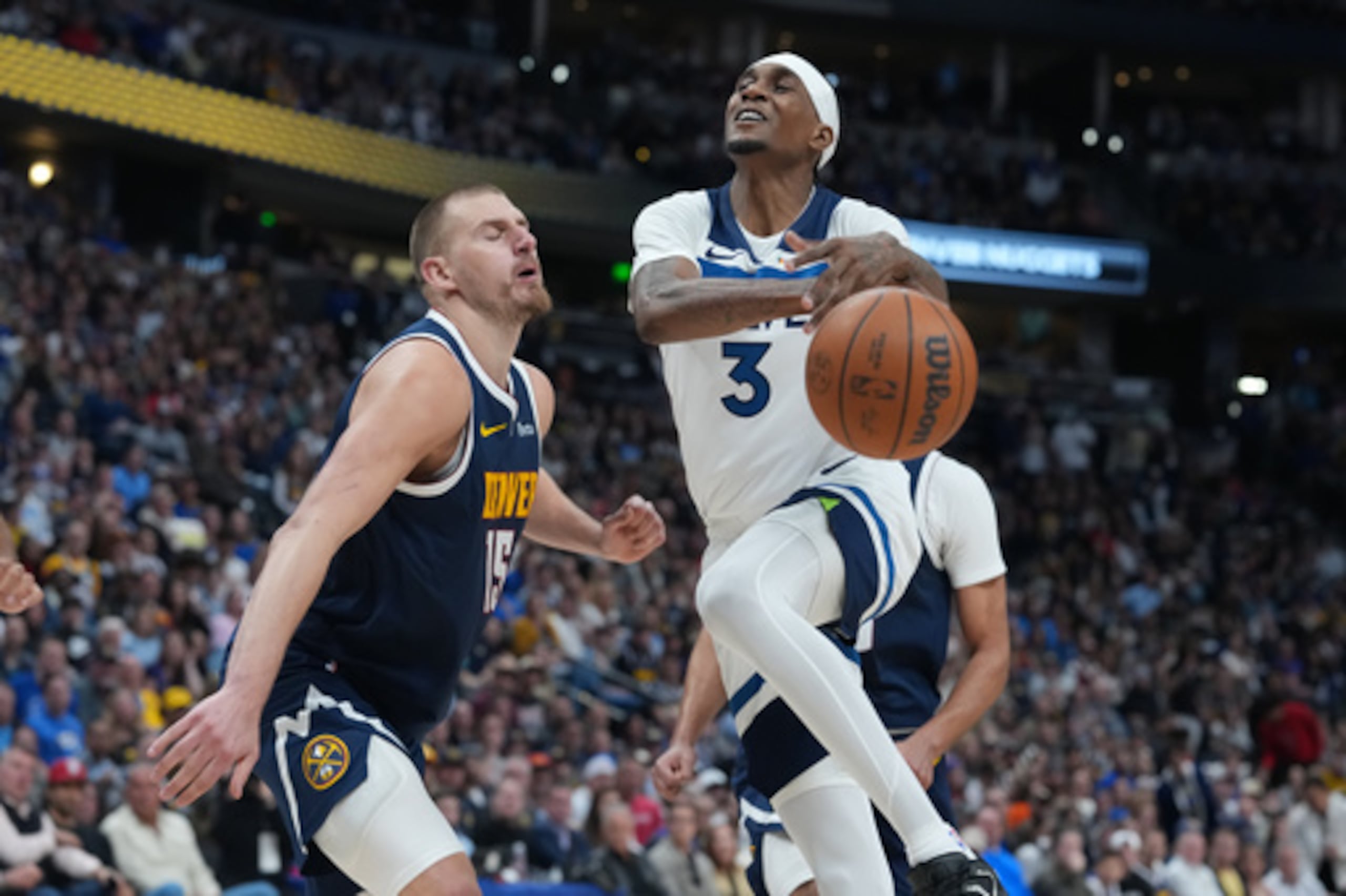 El alero de los Minnesota Timberwolves Jaden McDaniels, a la derecha, pierde el balón mientras conduce hacia la red mientras el pívot de los Denver Nuggets Nikola Jokic defiende en la segunda mitad del quinto partido de la primera ronda de los playoffs de baloncesto de la NBA el lunes 27 de abril de 2026, en Denver. (AP Photo/David Zalubowski)