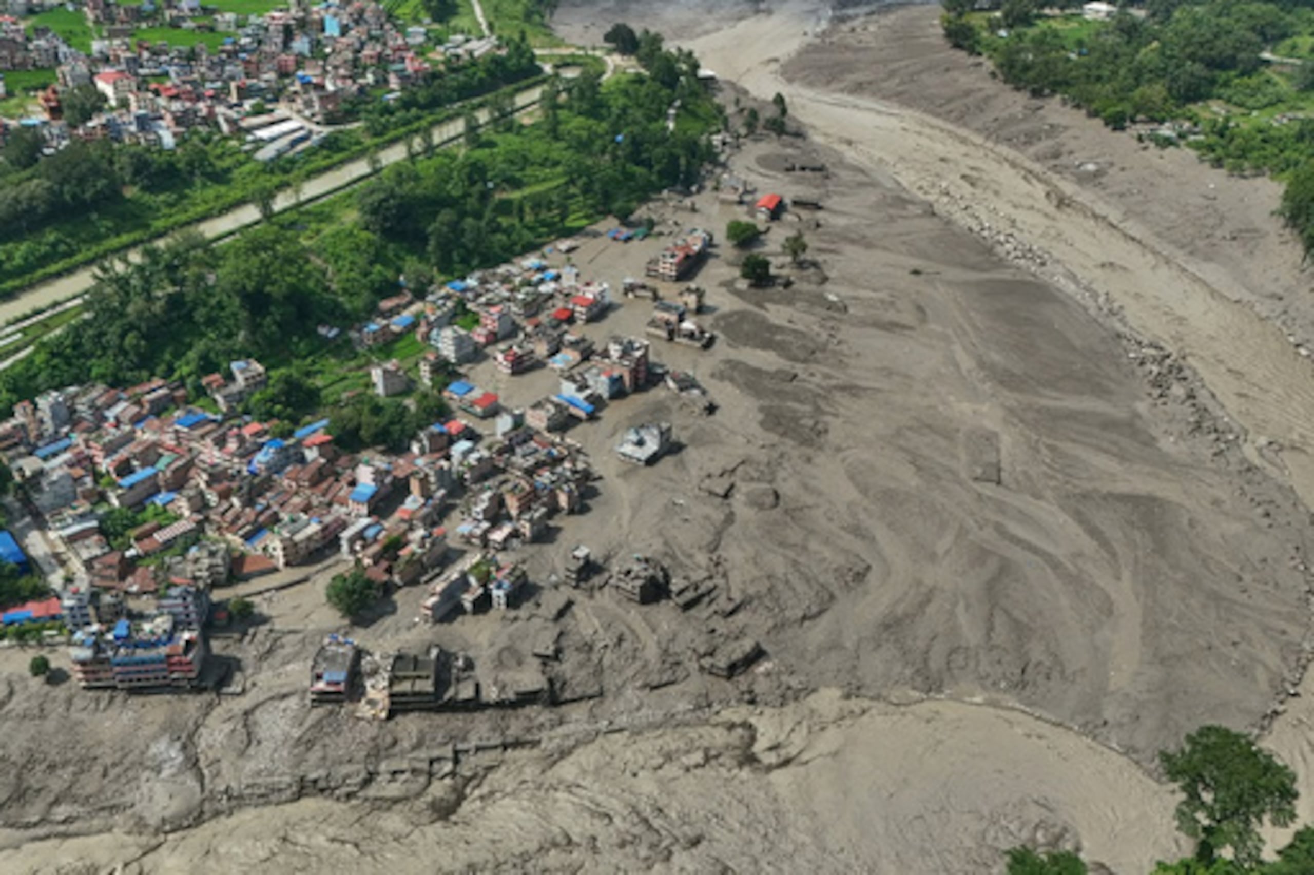 Varias casas dañadas se alzan en una situación precaria cerca de las orillas del río Trishuli, crecidas y repletas de escombros, tras las crecidas repentinas registradas el miércoles 26 de agosto de 2026 en el distrito de Nuwakot, en Nepal. (Foto AP/Niranjan Shrestha)