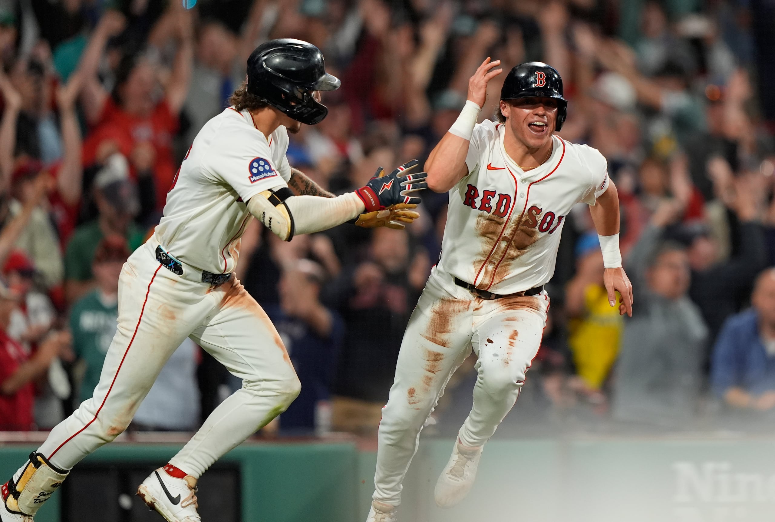 Nate Eaton, a la derecha, festeja la carrera que le dio la victoria a los Red Sox sobre los Athletics.