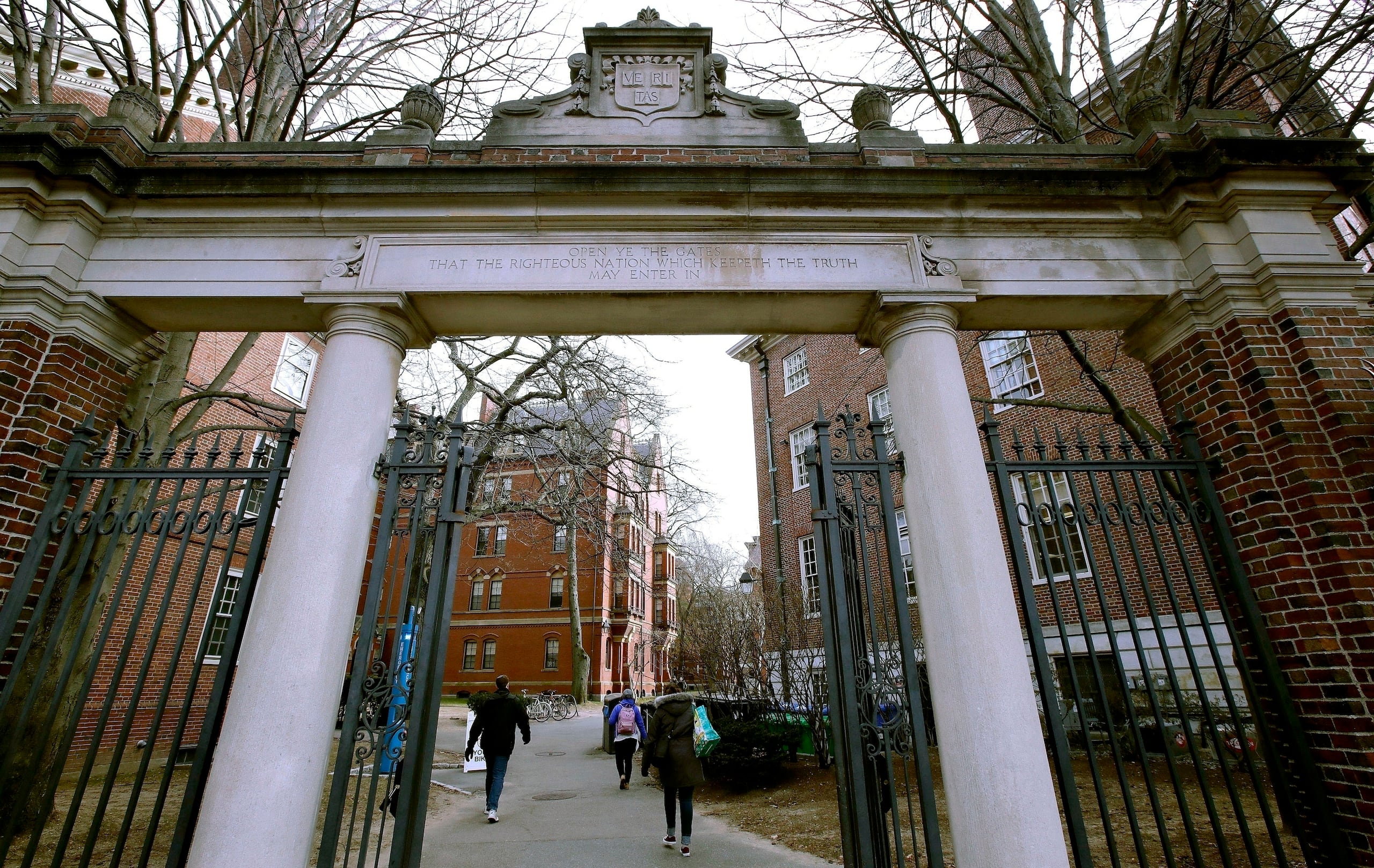 Algunos estudiantes ingresan por una puerta de la Universidad de Harvard, en Cambridge, Massachussetts. (AP Foto/Charles Krupa, archivo)