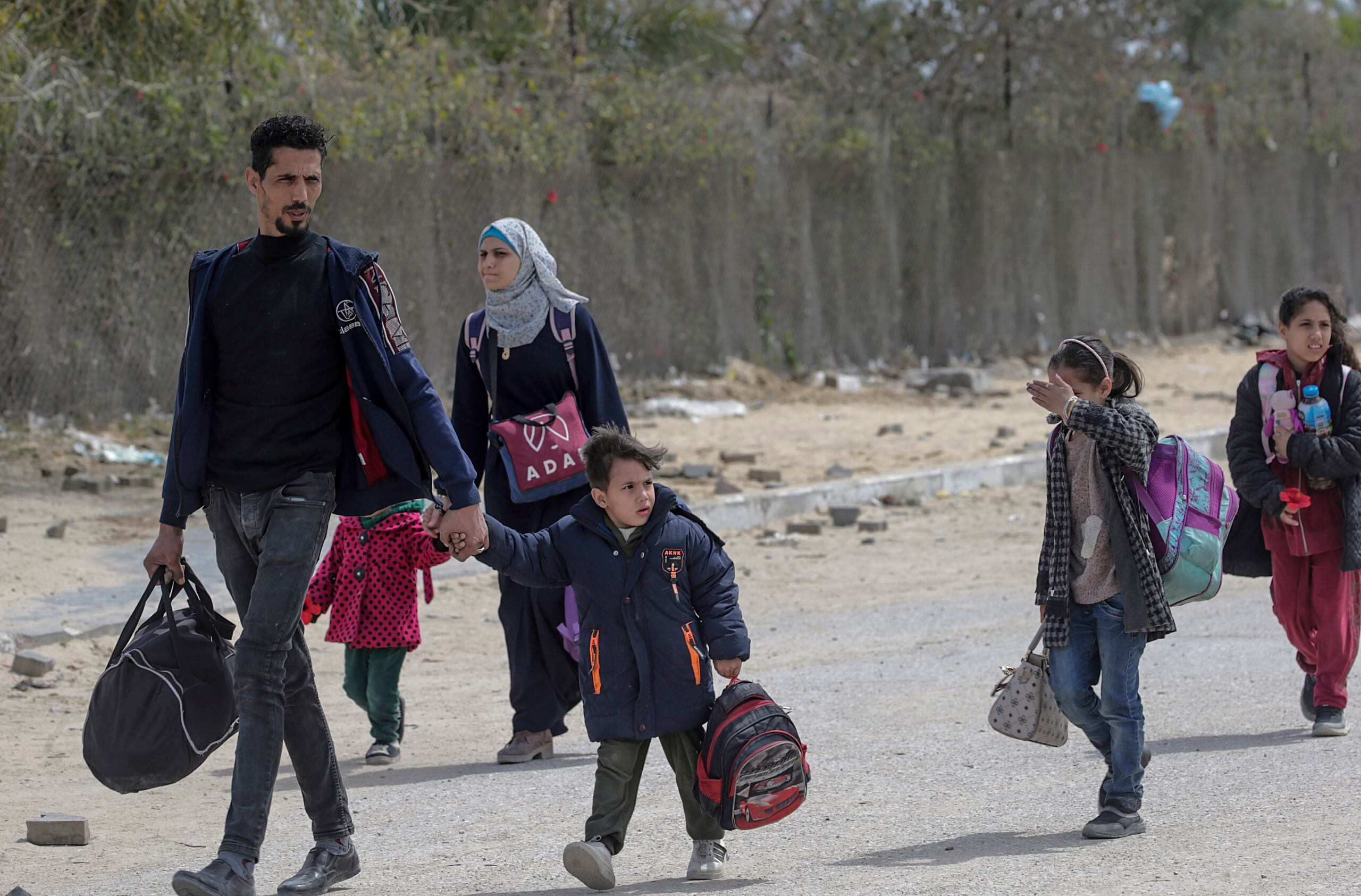 Palestinos desplazados internos, incluidos niños, cargan sus pertenencias después de que el ejército israelí pidiera a los residentes de Jan Yunis que abandonaran sus hogares y se dirigieran a campamentos en Rafah, cerca de la frontera con Egipto, en una imagen del 24 de marzo de 2024. (EFE/EPA/MOHAMMED SABER)