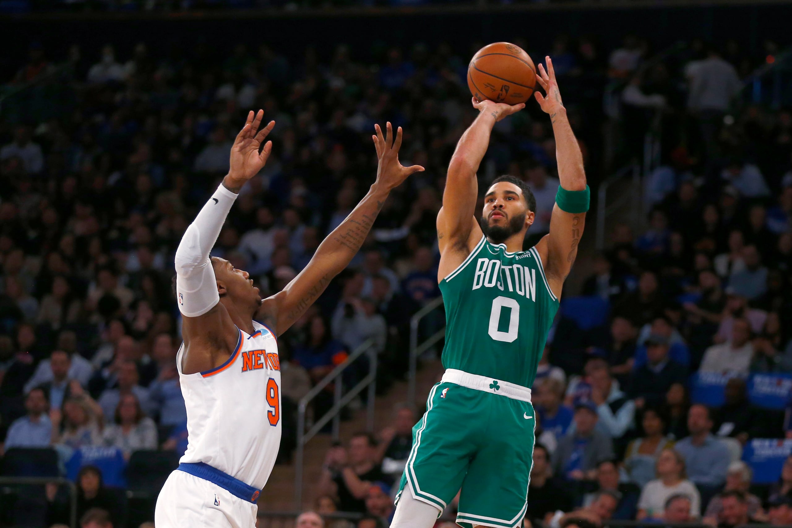 Jayson Tatum, alero de los Celtics de Boston, dispara frente a RJ Barrett, de los Knicks de Nueva York, en el encuentro del miércoles 25 de octubre de 2023 (AP Foto/John Munson)