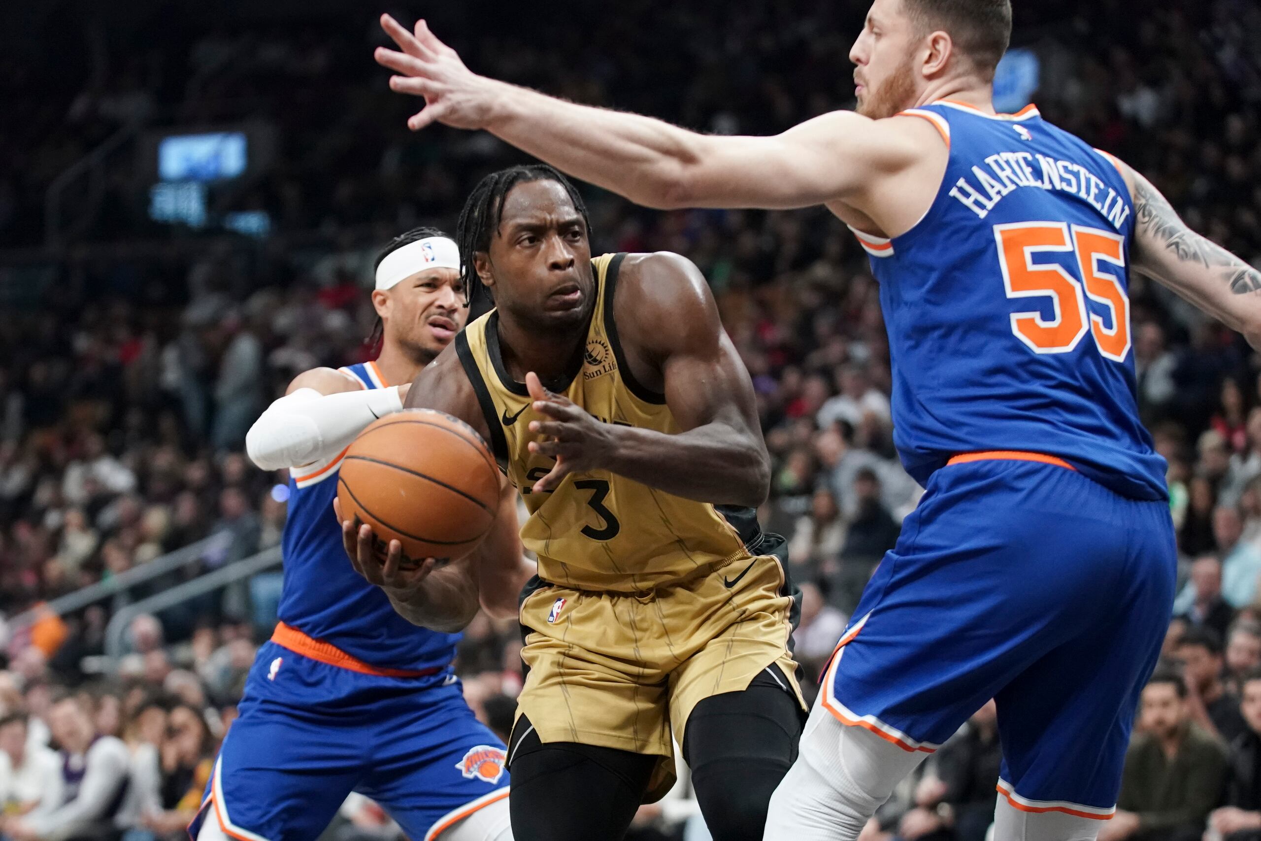 El alero OG Anunoby intenta avanzar con el balón mientras lo defiende el pívot de los Knicks de Nueva York, Isaiah Hartenstein.