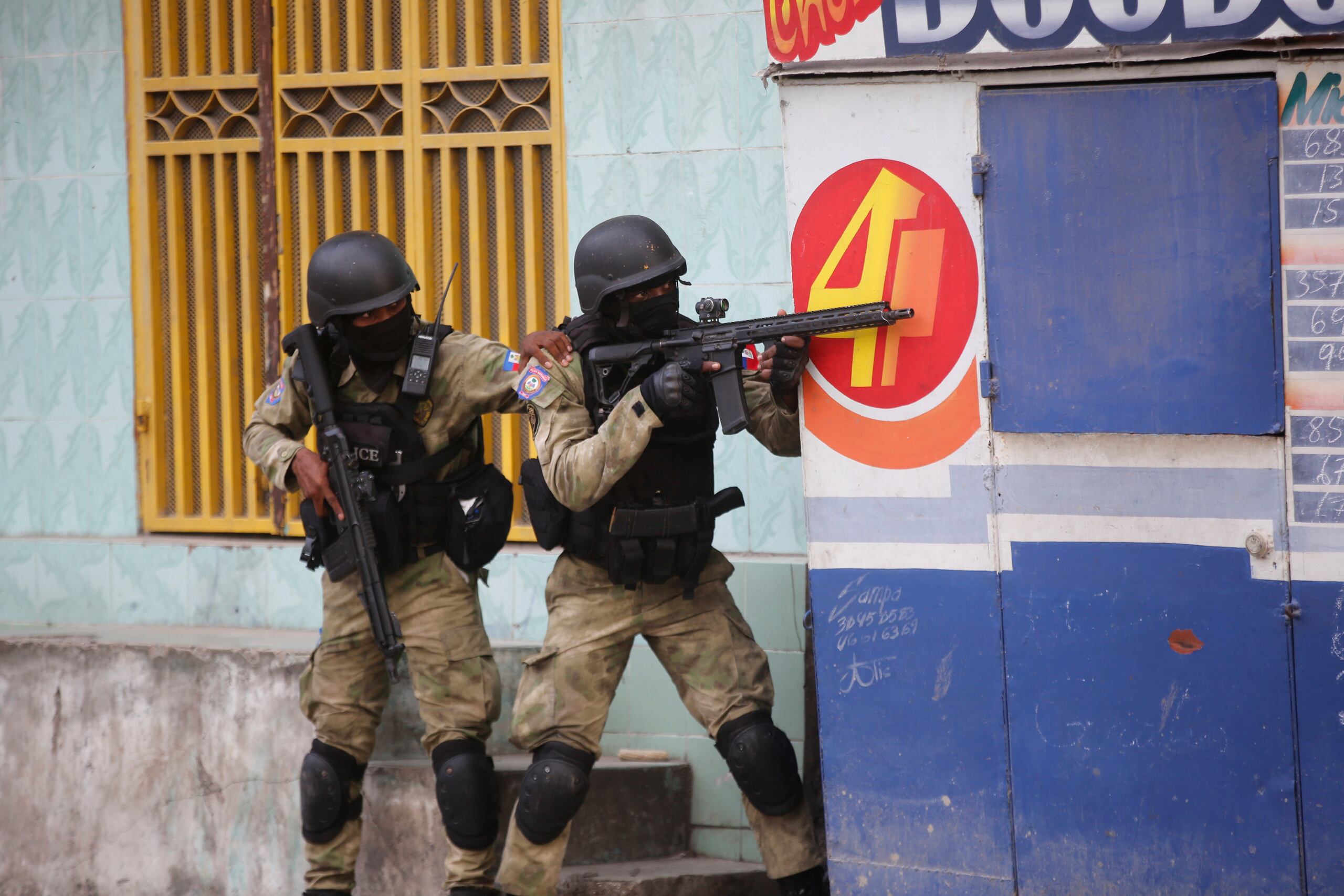 Policías se resguardan durante un operativo antipandillas en el vecindario Portail el jueves 29 de febrero de 2024, en Puerto Príncipe, Haití. (AP Foto/Odelyn Joseph)