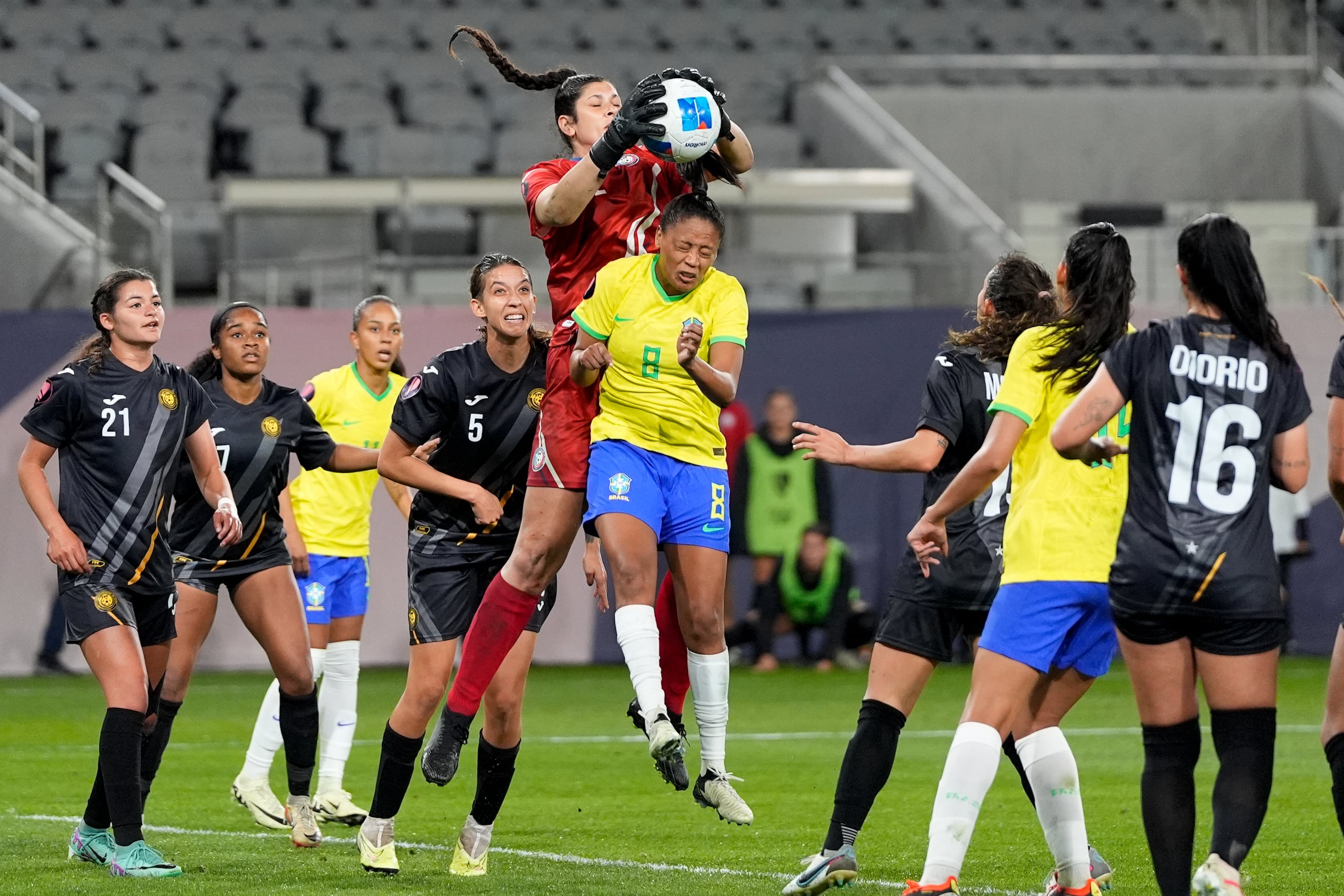 La portera de Puerto Rico, Sydney Martínez, agarra una pelota por arriba de Ary Borges durante la acción de la primera mitad del partido anoche.