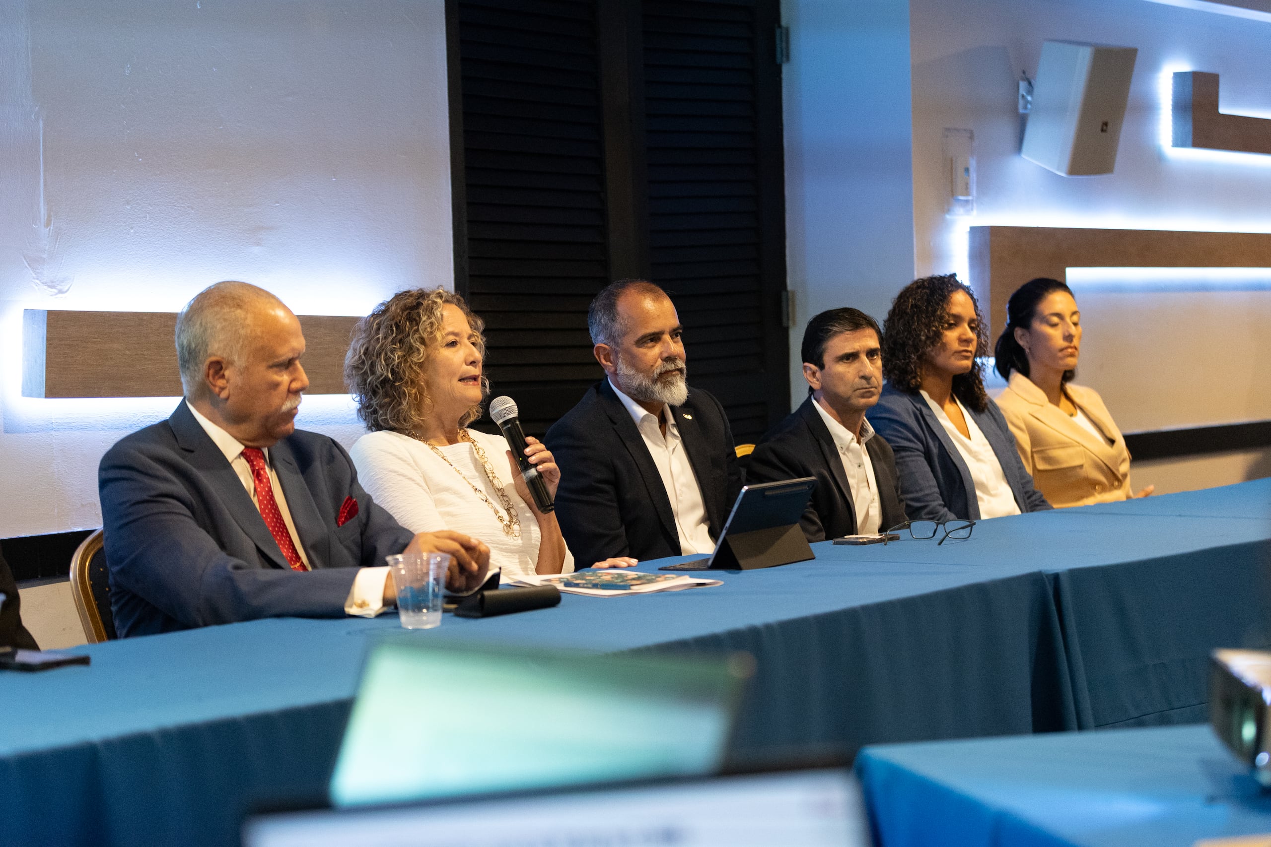 Sara Rosario conversa acompañada por otros directivos del Copur. Entre ellos están el primer vicepresidente, Carlos Beltrán, el director ejecutivo del Departamento de Alto Rendimiento, Fernando Olivero Lora, ambos en ese orden a su cada uno de sus lados.