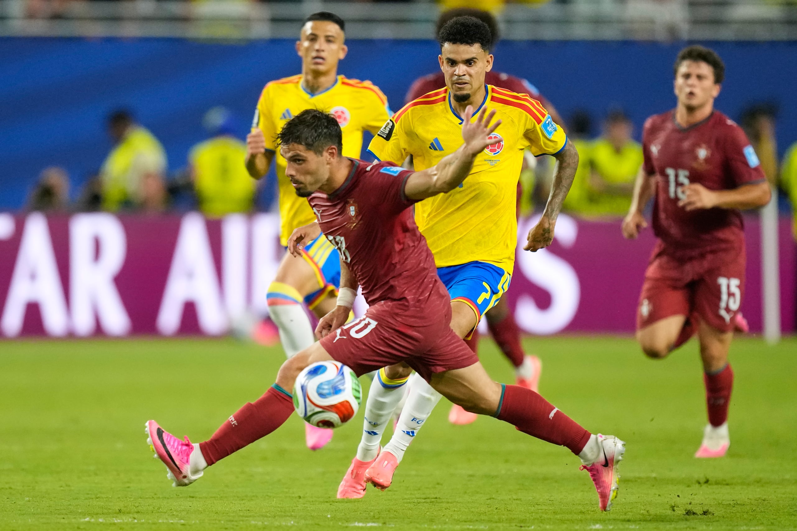 El colombiano Luis Diaz y el portugués Pedro Neto pugnan por el balón en el partido del Grupo K del Mundial.