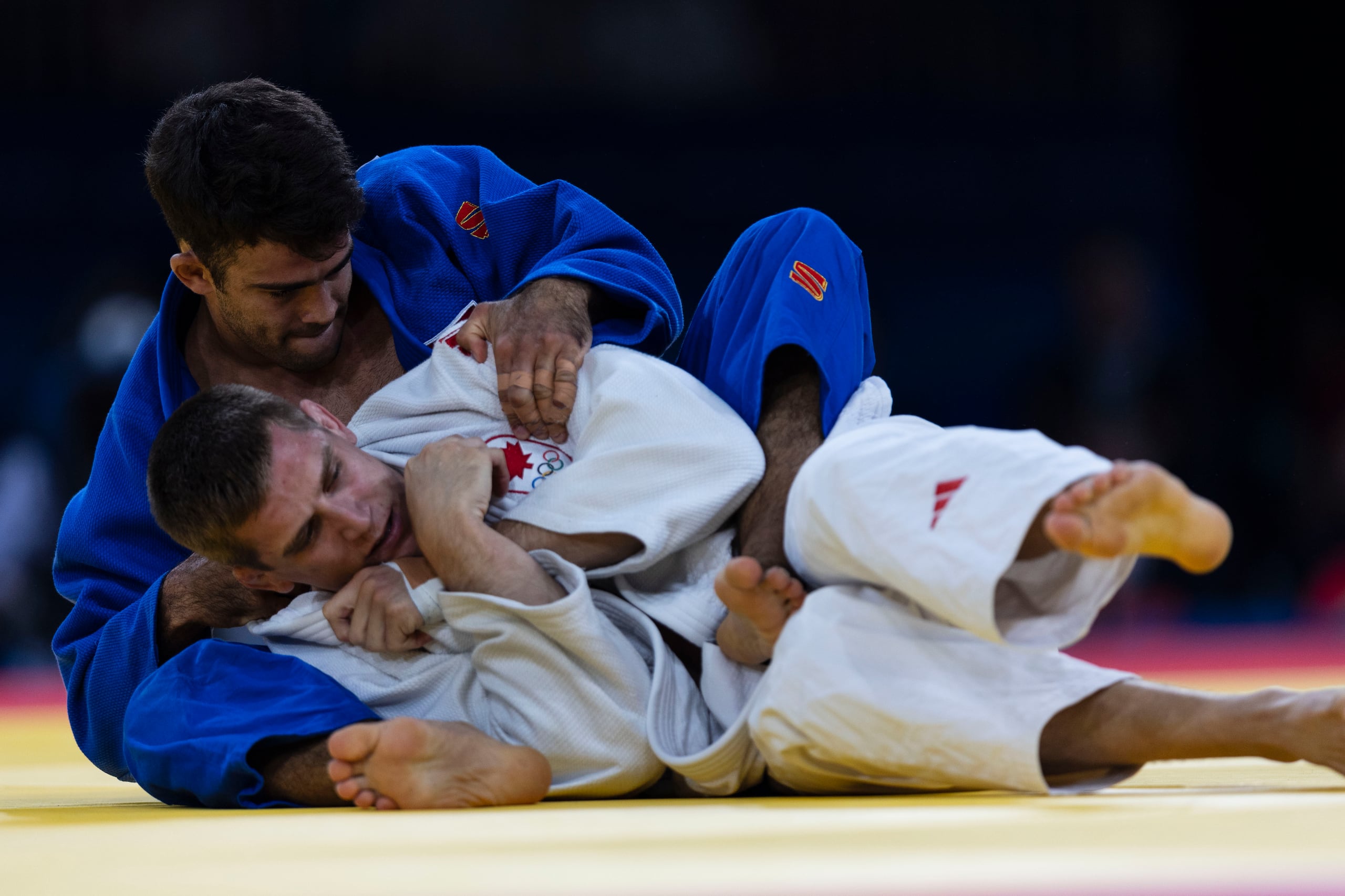Adrián Gandín, en uniforme azul, lucha una movida con el canadiense Francois Drapeau.