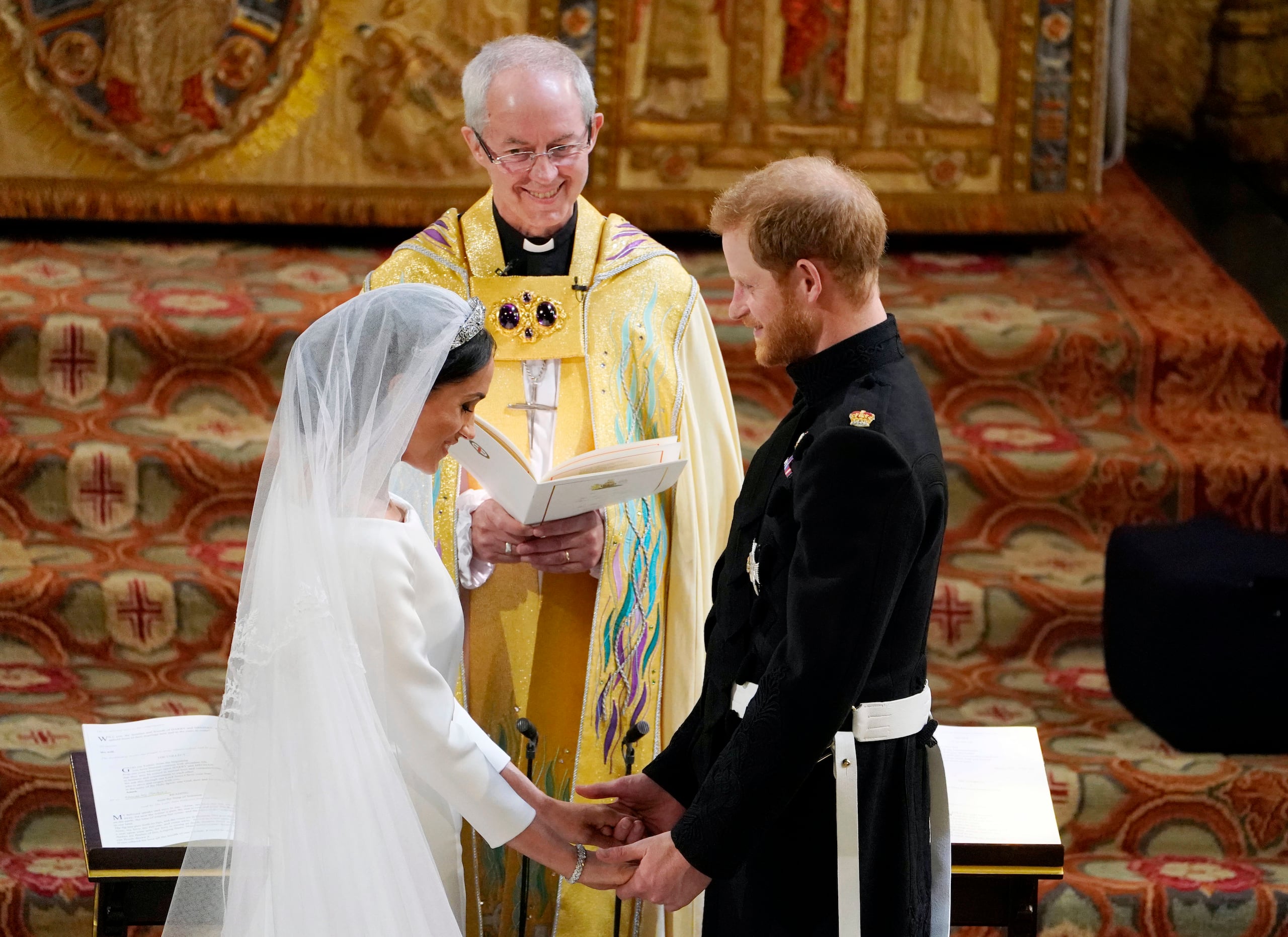 El príncipe Enrique y Meghan Markle intercambian votos en la Capilla de San Jorge, en el Castillo de Windsor, durante su servicio de boda, oficiado por el Arzobispo de Canterbury, Justin Welby, el 19 de mayo de 2018.
