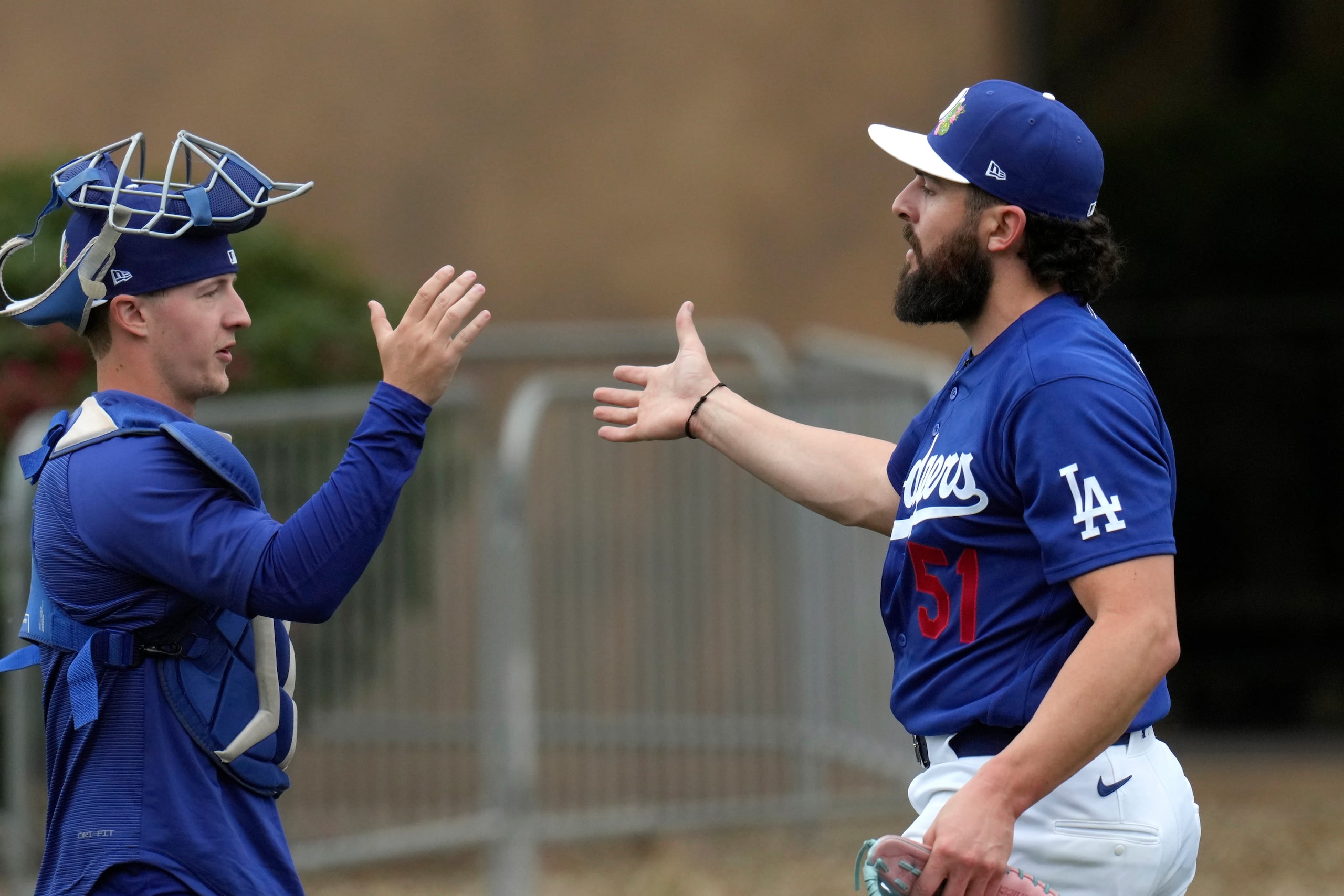 Alex Vesia, derecha, lanzador de los Dodgers de Los Ángeles, saluda a un receptor después de una sesión de trabajo en los entrenamientos de primavera el viernes 13 de febrero de 2026, en Phoenix. (AP Foto/Ross D. Franklin)