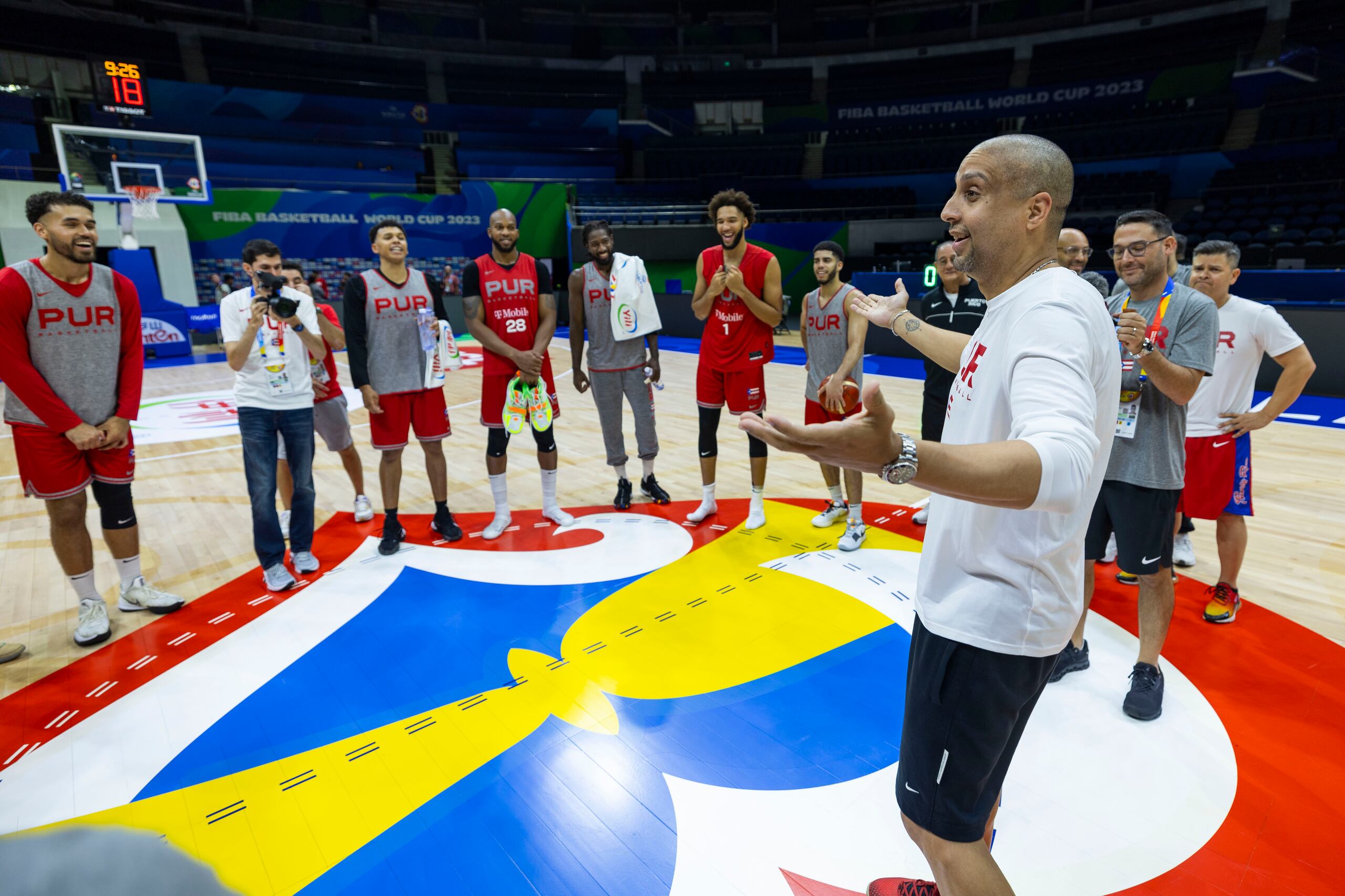 Nelson Colón, técnico de la selección de Puerto Rico, conversa con el equipo en el medio del tabloncillo.