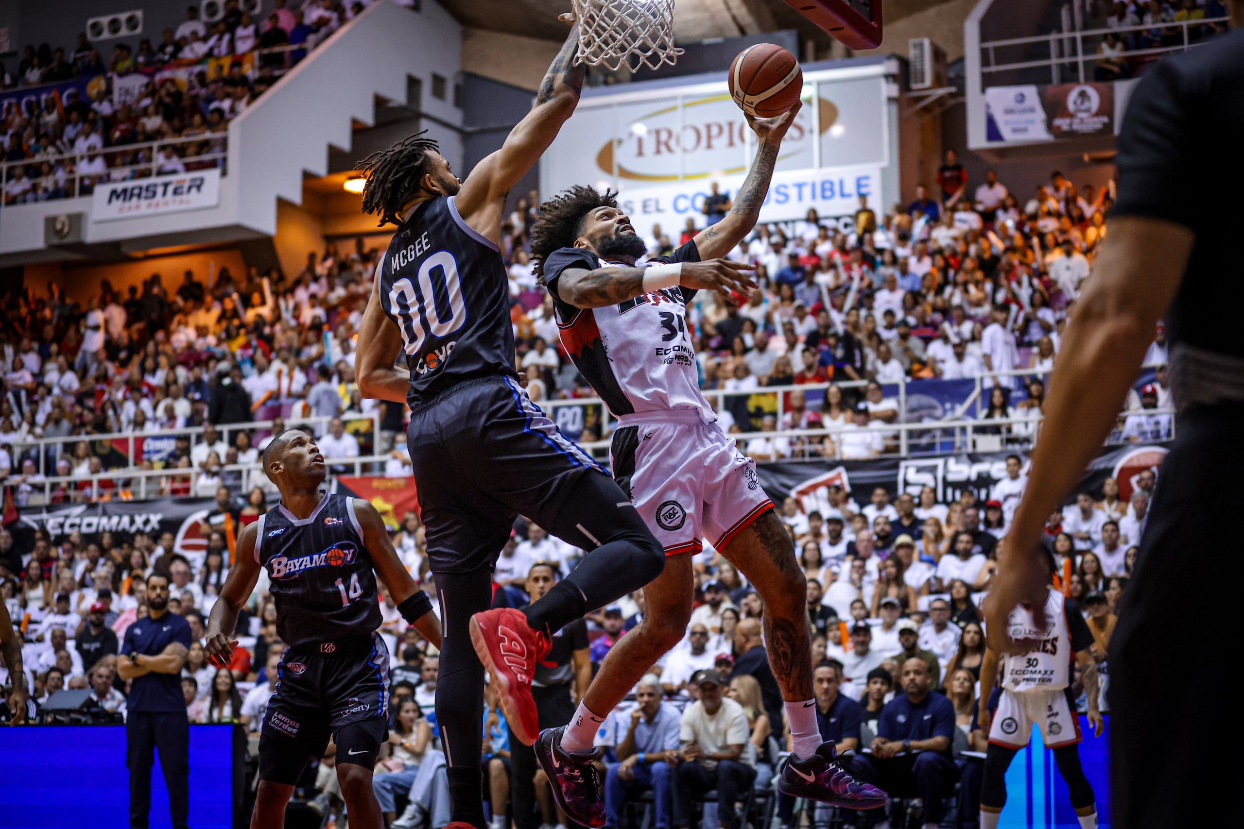 Jordan Murphy, de los Leones de Ponce, ataca el canasto ante la defensa de JaVale McGee, de los Vaqueros de Bayamón, en el cuarto juego de la final del BSN.
