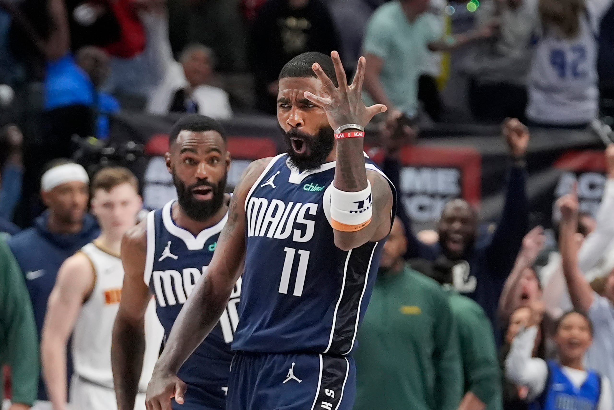 El armador de los Mavericks de Dallas, Kyrie Irving (11), reacciona mientras su compañero Tim Hardaway Jr. se acerca luego de anotar el triple ganador.
