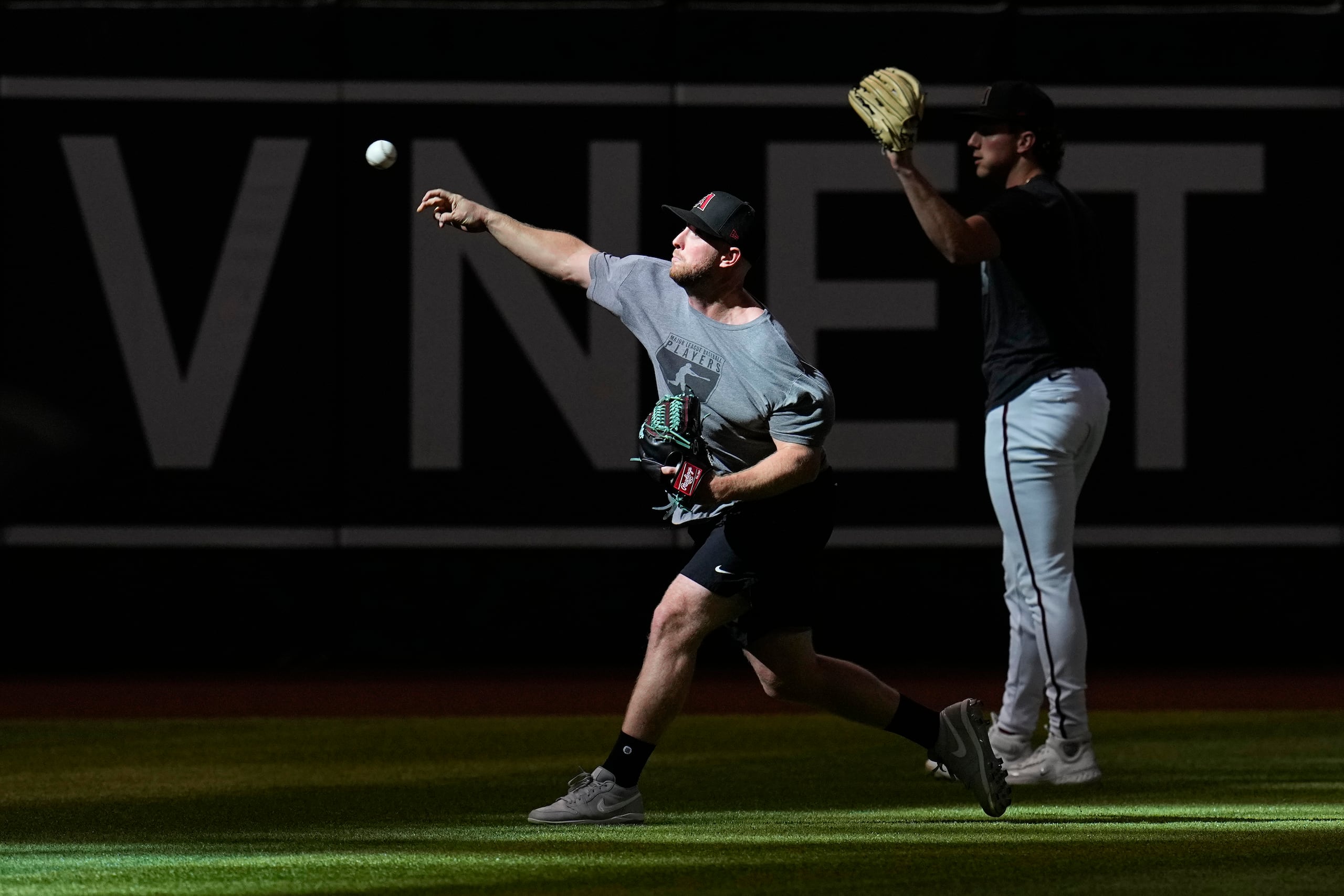 Merrill Kelly, a la izquierda, suelta su brazo en una práctica en preparación para la Serie del Campeonato de la Liga Nacional. El derecho será el abridor del primer partido de la serie el lunes en Filadelfia.