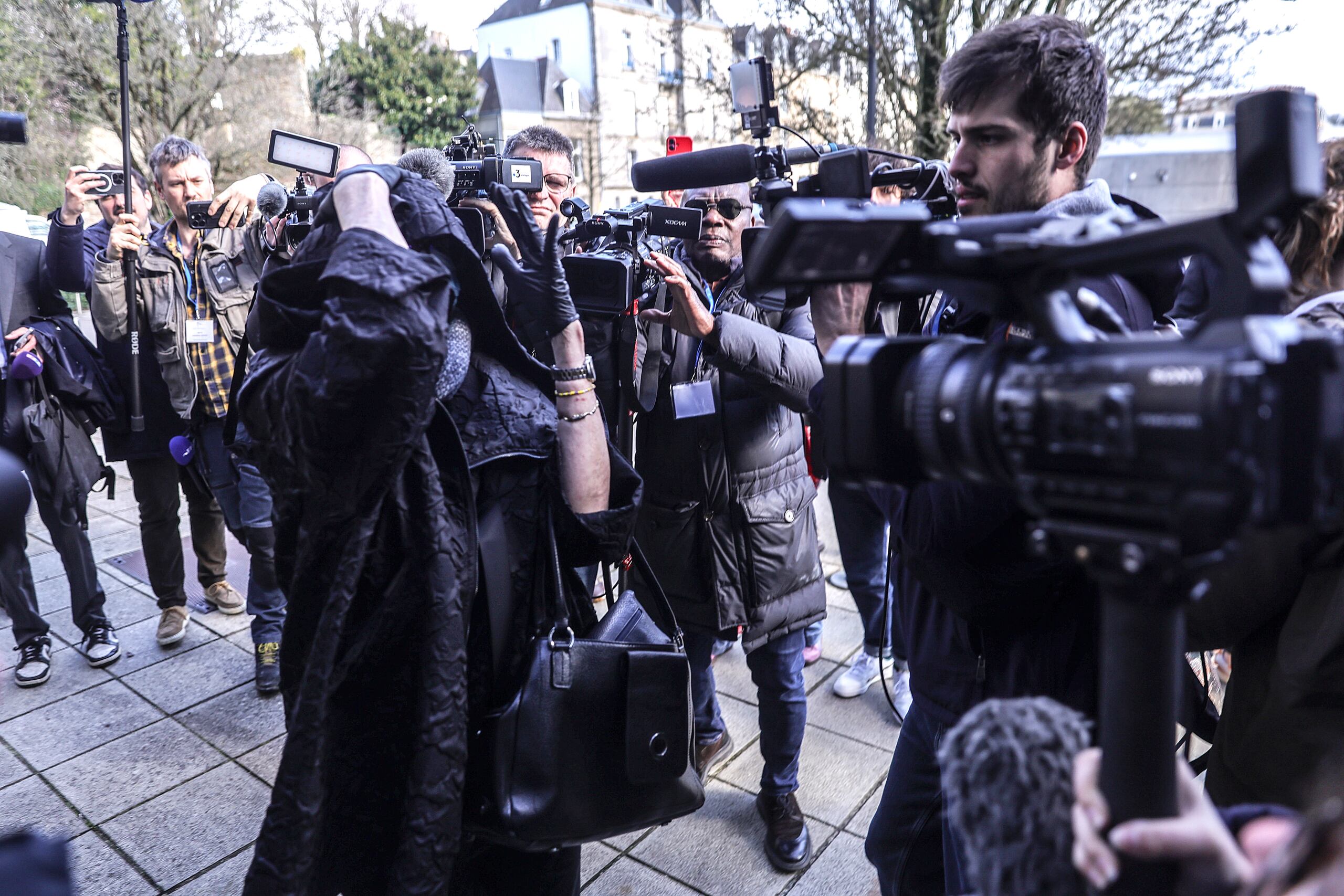 Marie France (L frente), supuesta exesposa del excirujano Joel Le Scouarnec, está rodeada de periodistas a su llegada al tribunal penal de Morbihan en Vannes, Bretaña, Francia, 25 de febrero de 2025.