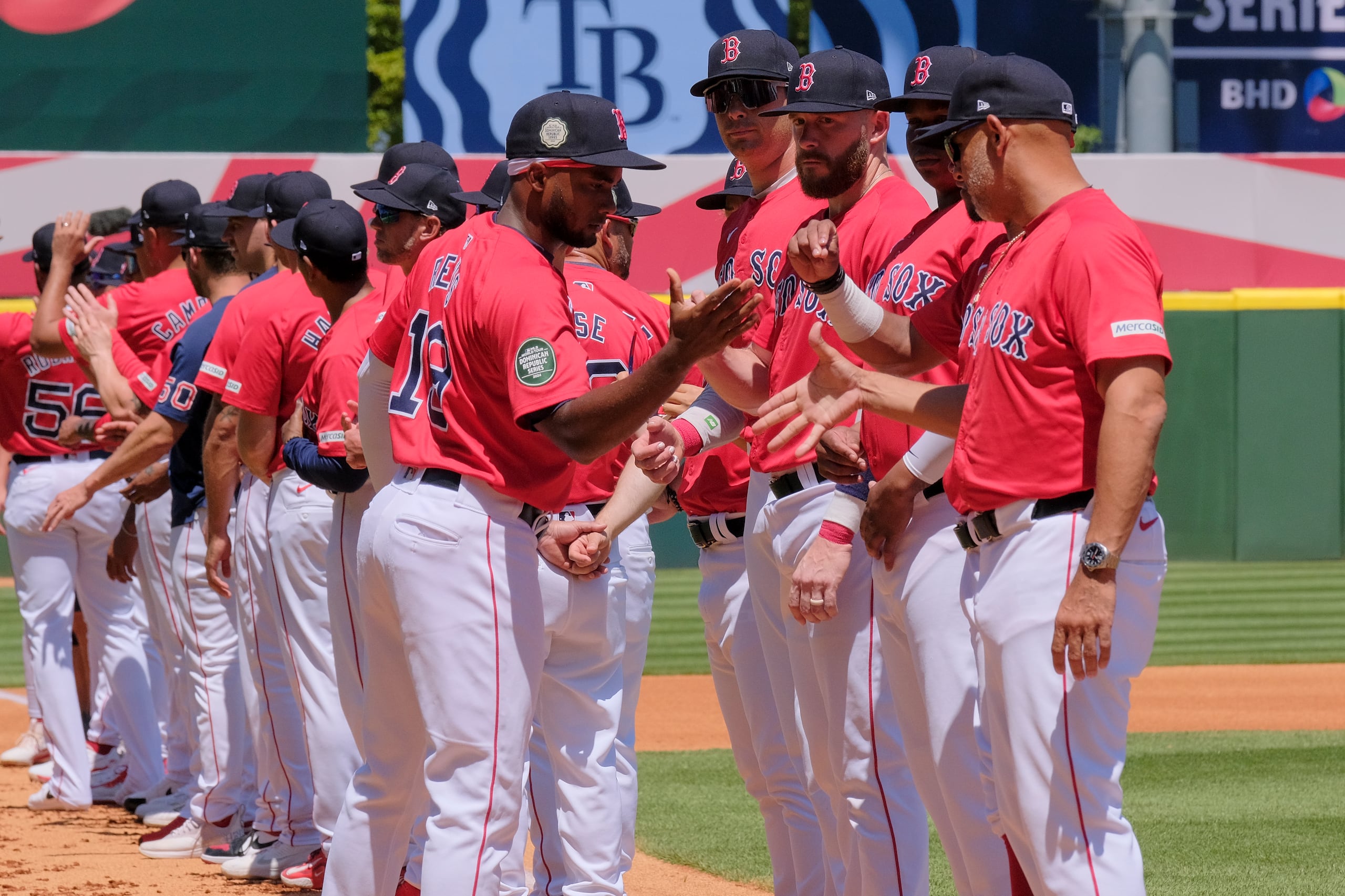 Pablo Reyes, al centro, saluda a Alex Cora y sus compañeros previo al partido de ayer en Dominicana.