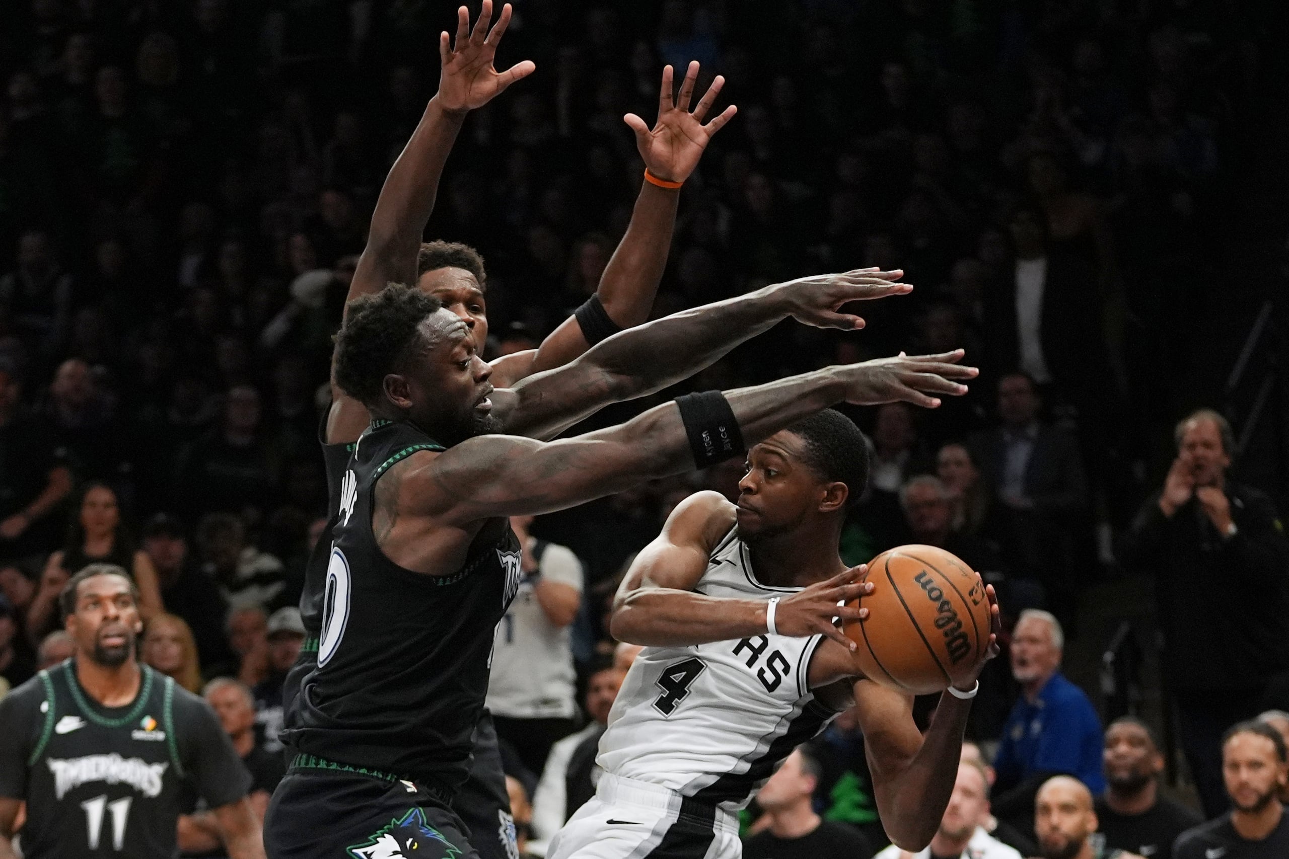 De'aaron Fox (4), de los Spurs de San Antonio, es presionado por Julius Randle, izquierda, y Anthony Edwards, centro, durante la segunda mitad del cuarto juego de la serie de segunda ronda de los playoffs del baloncesto de la NBA, el domingo 10 de mayo de 2026, en Minneapolis. (AP Foto/Abbie Parr)