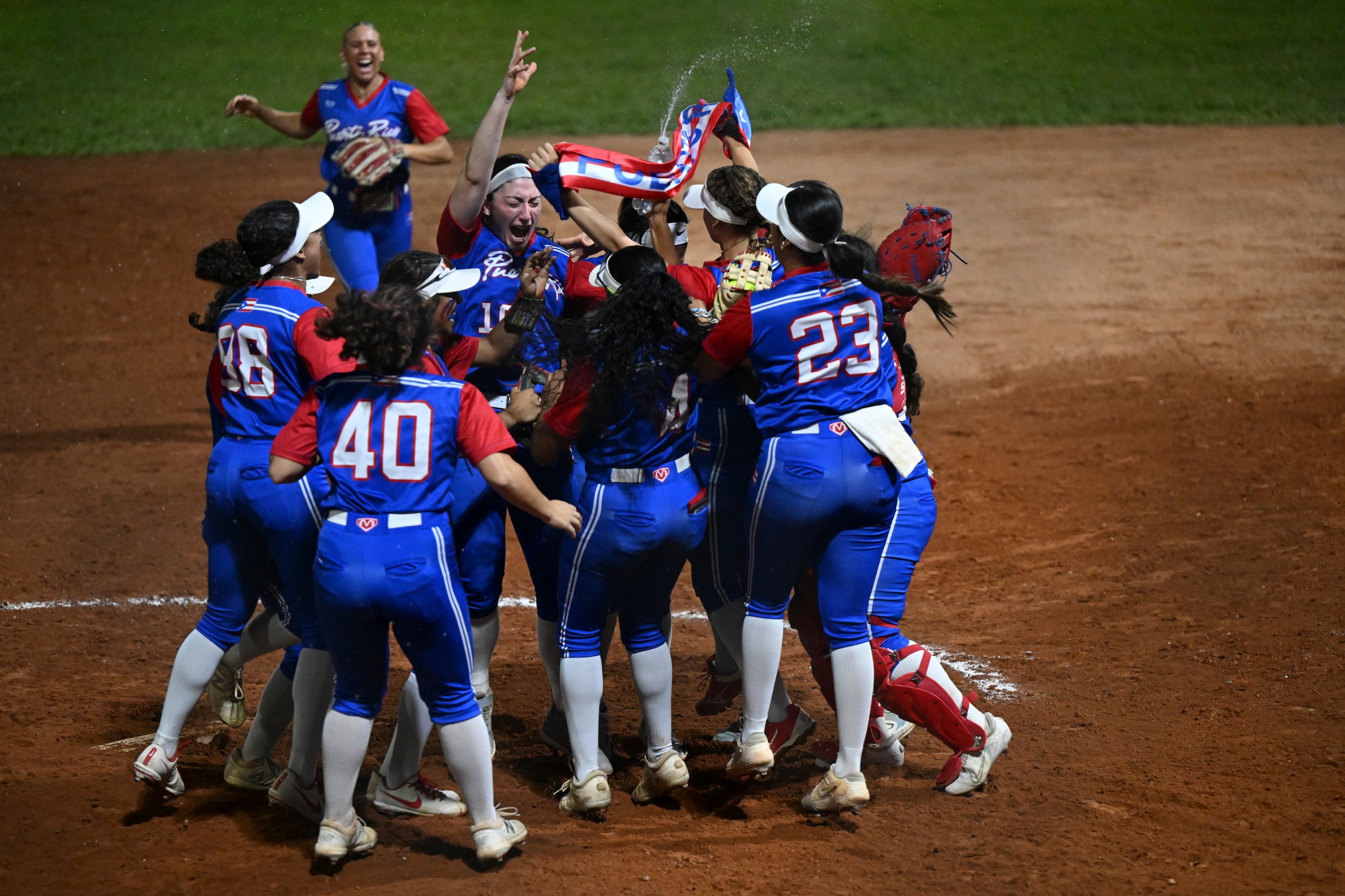 La novena boricua celebra el triunfo ante Cuba sobre el terreno de juego.