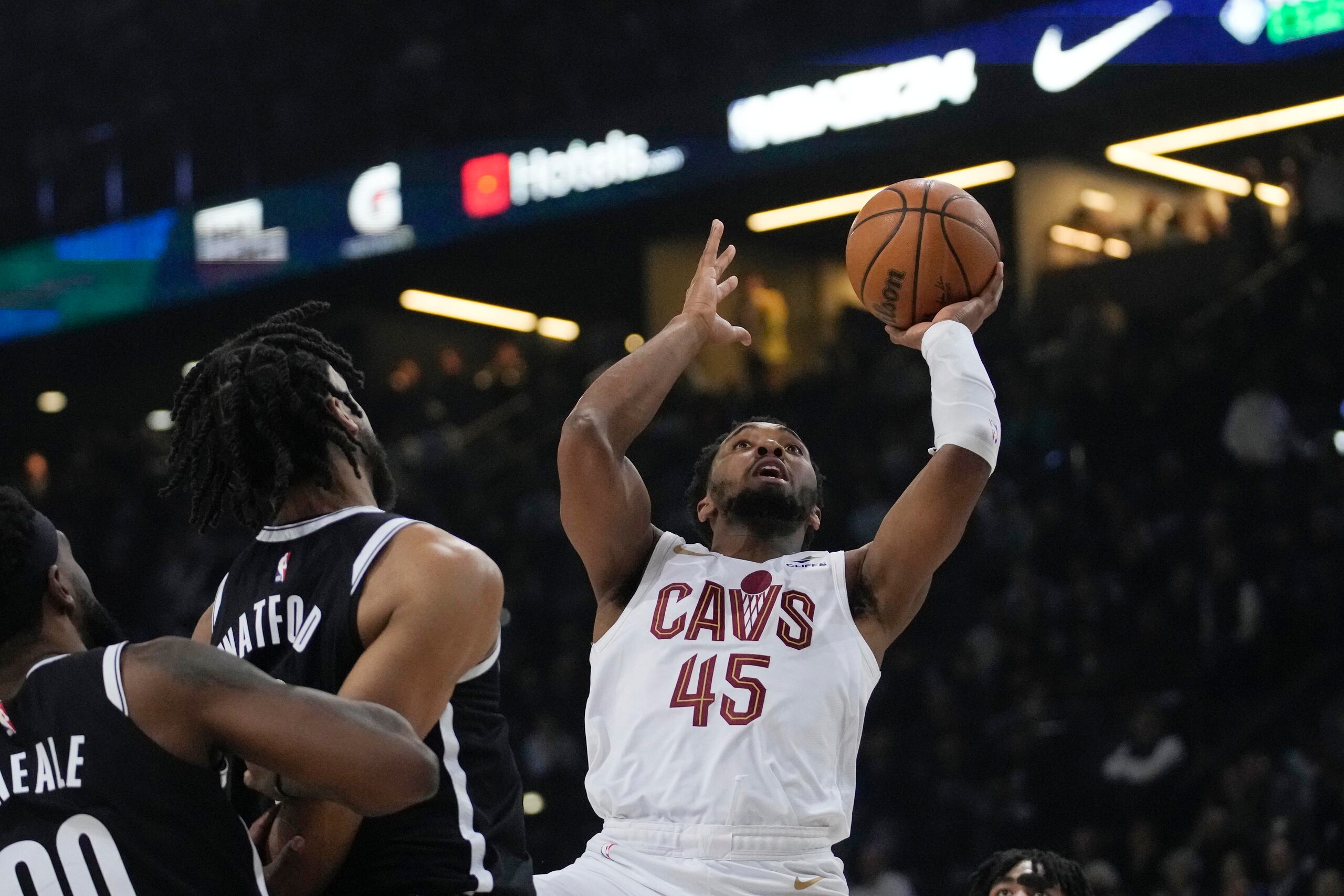 Donovan Mitchell, de los Cavaliers, realiza un disparo ante la defensa de los jugadores de los Nets.