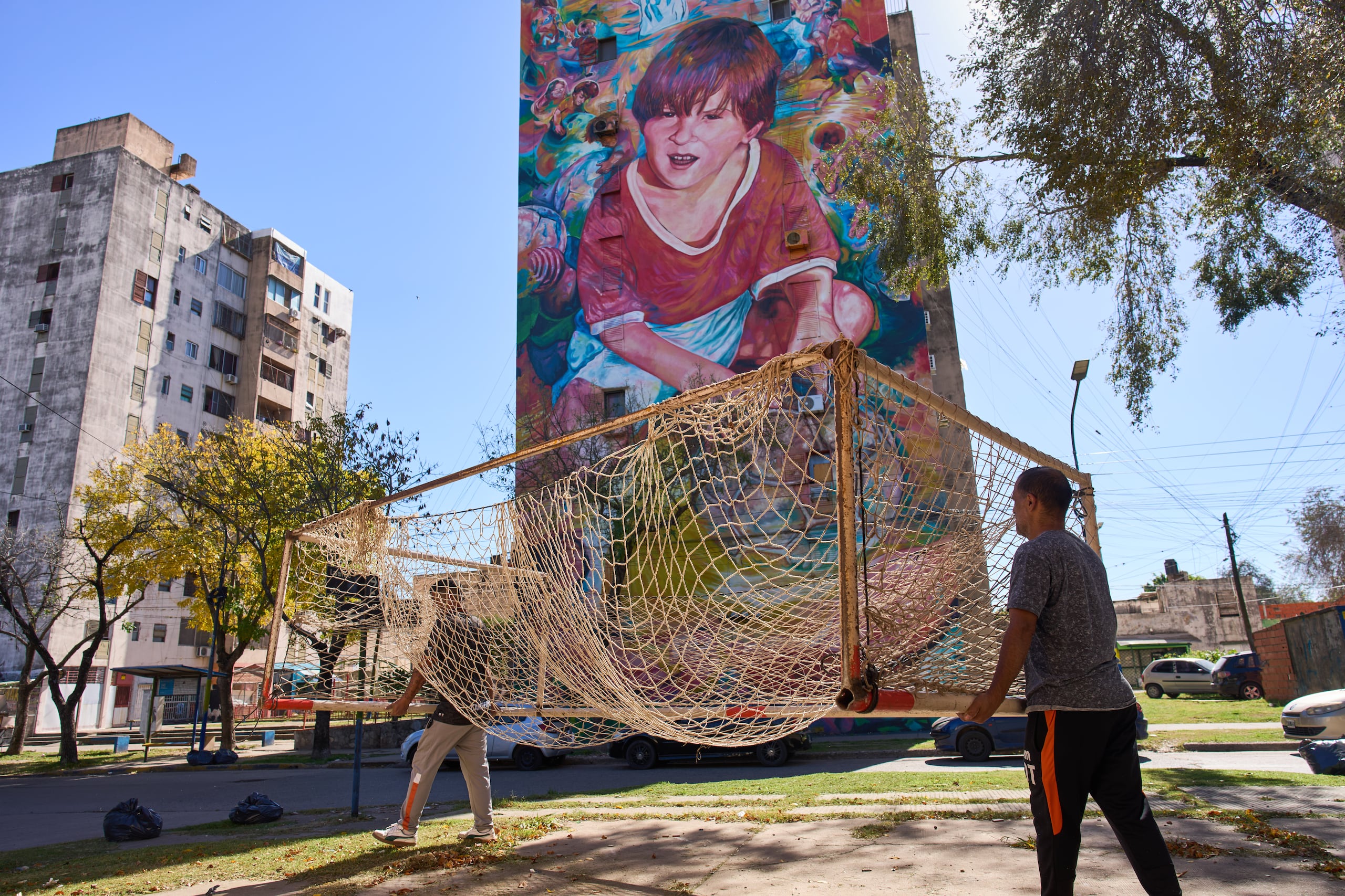 Empleados del club de fútbol Grandoli cargan un arco en la cancha para un partido de fútbol infantil en Rosario, Argentina, el sábado 2 de mayo de 2026. (AP Foto/Rodrigo Abd)
