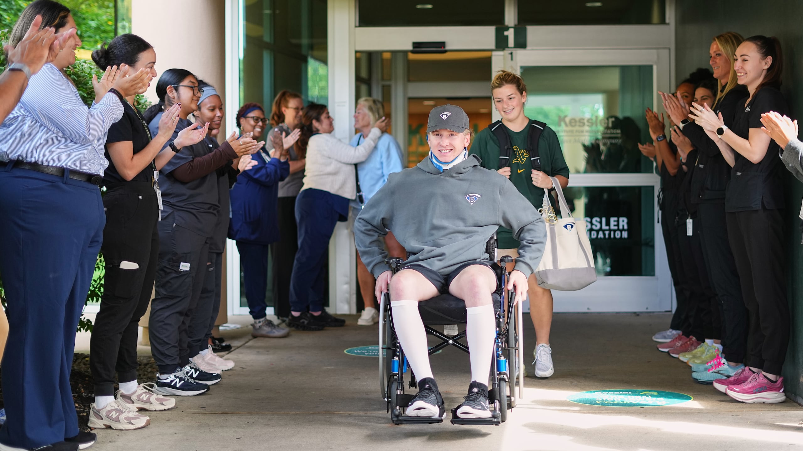 Los cuidadores aplauden a Ryan Lasko, una promesa de las ligas menores de los Athletics que quedó paralítico tras una colisión en el campo exterior hace más de dos meses, con motivo de su alta del Instituto Kessler de Rehabilitación, en West Orange (Nueva Jersey), el miércoles 16 de septiembre de 2026. (Foto AP/Matt Rourke)