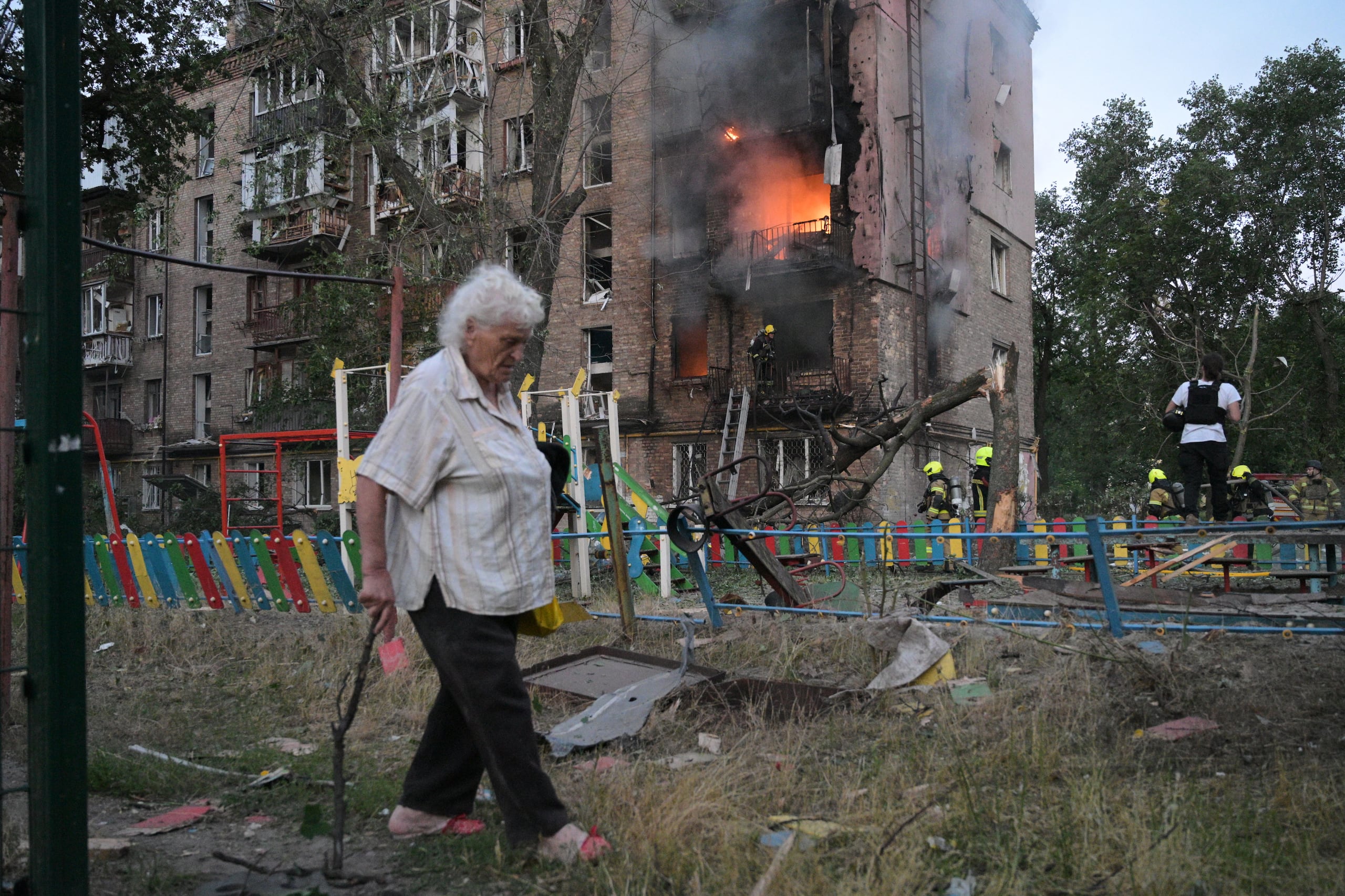 Una mujer pasa junto a un edificio de apartamentos en llamas tras un ataque con misiles rusos, el jueves 2 de julio de 2026, en Kiev, Ucrania. (AP Foto/Danylo Antoniuk)