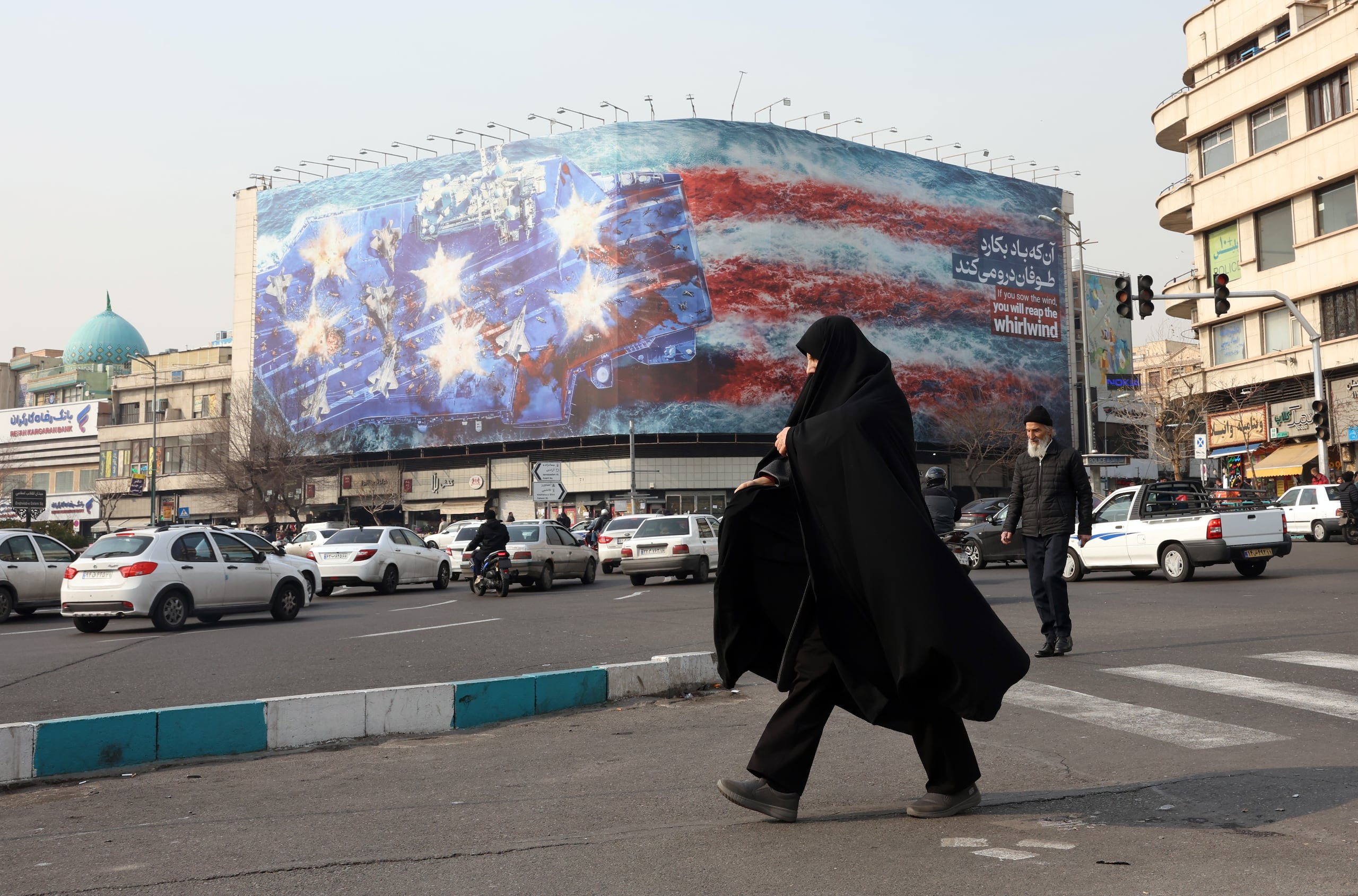 La imagen pintada de varios aviones dañados en la cubierta de vuelo de un portaaviones lleva el lema: “Si siembras el viento, cosecharás la tempestad”. EFE/EPA/ABEDIN TAHERKENAREH
