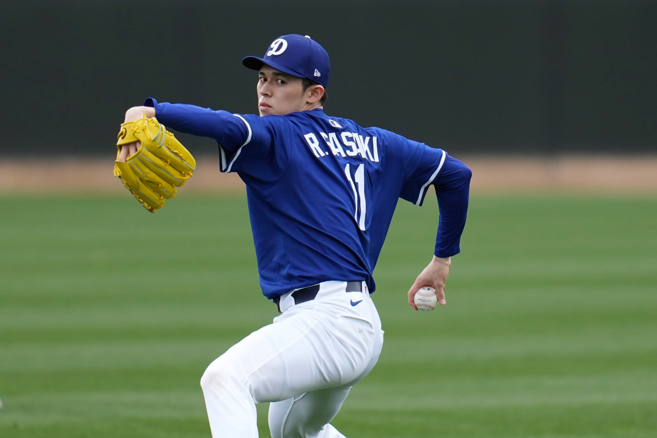 Roki Sasaki, lanzador japonés de los Dodgers de Los Ángeles, calienta el brazo en las instalaciones de los campos de primavera del equipo, el miércoles 12 de febrero de 2025, en Phoenix. (AP Foto/Ross D. Franklin)