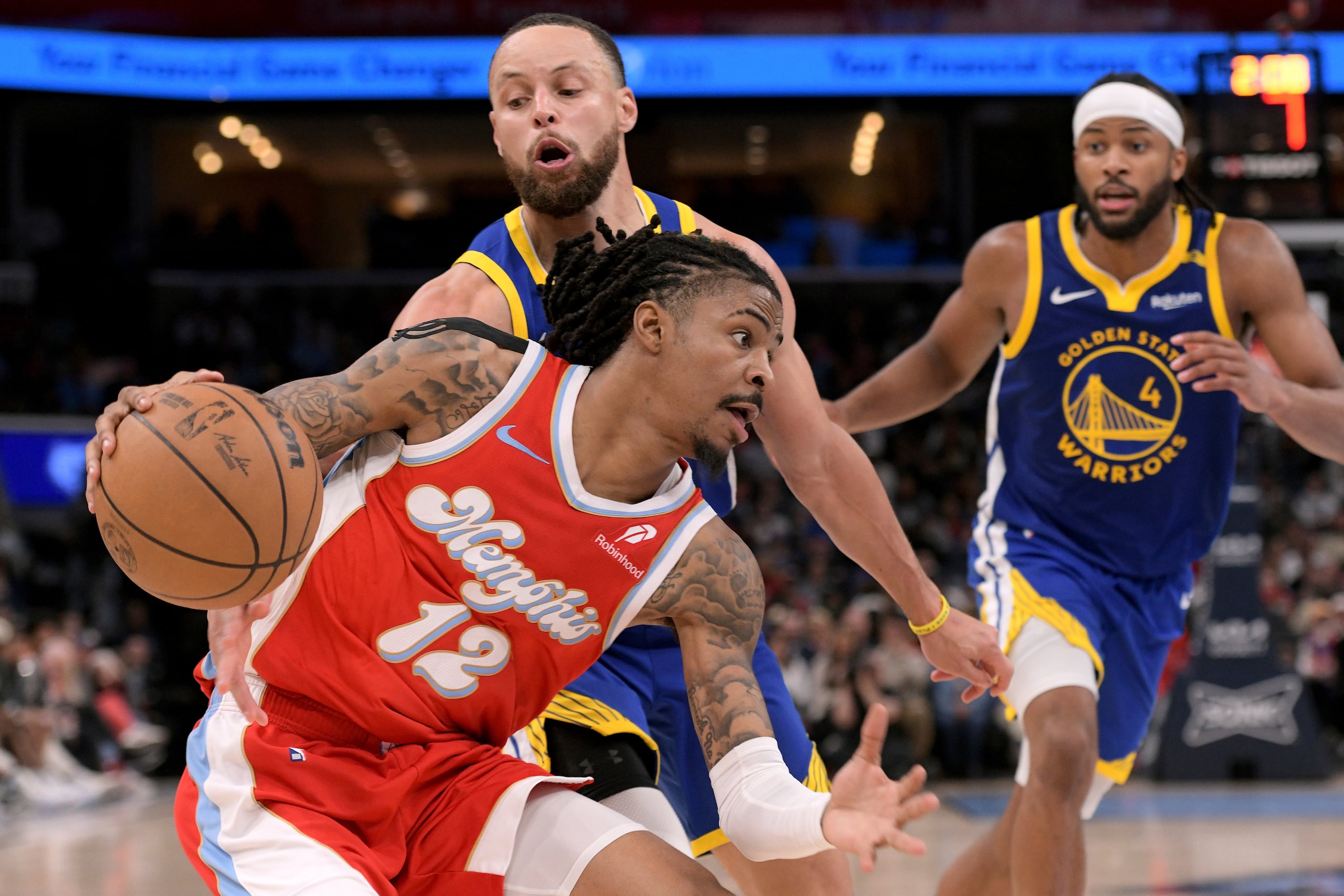 Ja Morant, de los Grizzlies de Memphis, conduce el balón ante Stephen Curry, de los Warriors de Golden State.