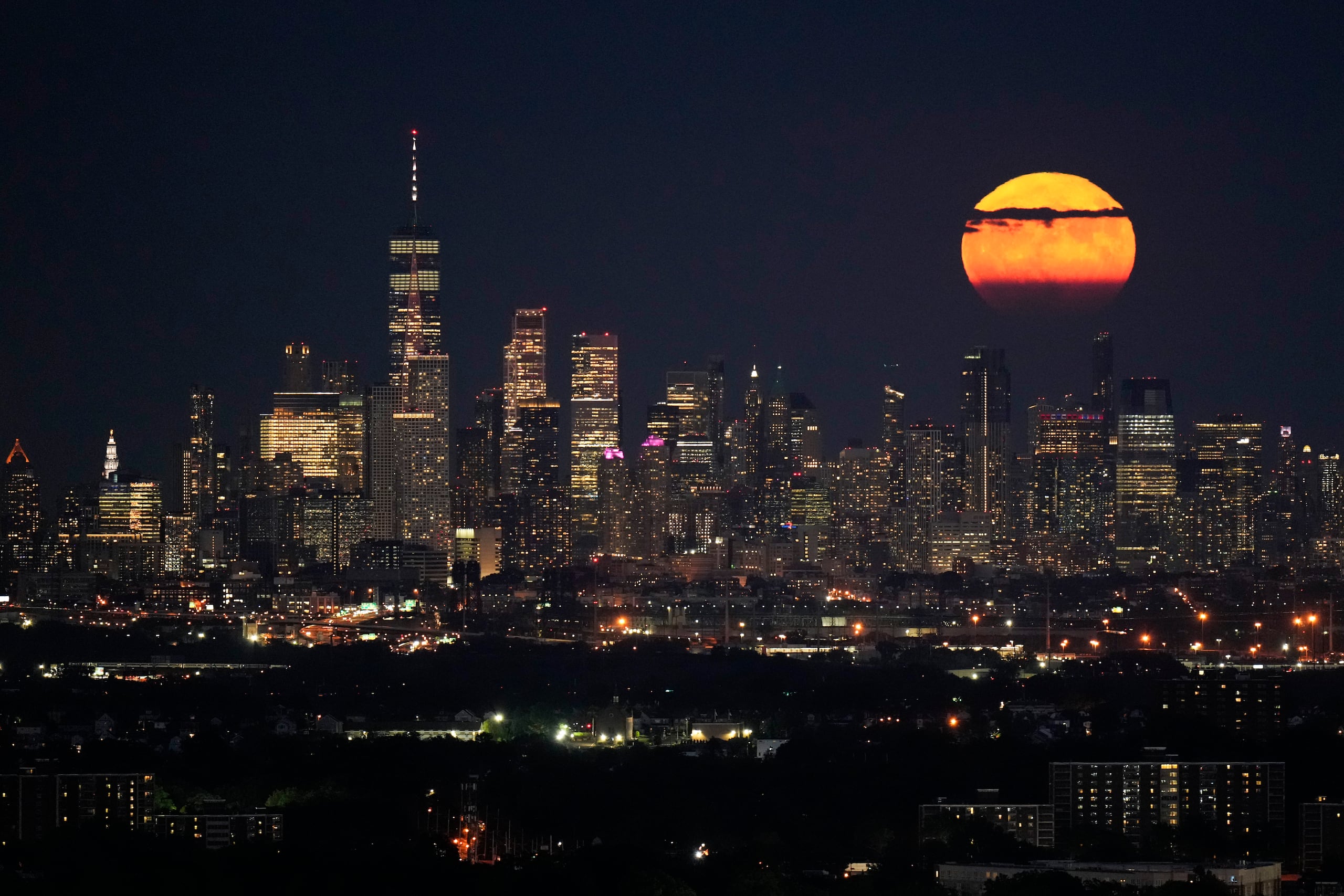 The moon rises through clouds over the skyline of lower Manhattan as seen from West Orange, N.J., Tuesday, Aug. 1, 2023. The first of two supermoons in August graced the skies on Tuesday. A supermoon is broadly defined as a full moon that is closer to the Earth than normal. That makes it appear slightly brighter and bigger in the sky. (AP Photo/Seth Wenig)