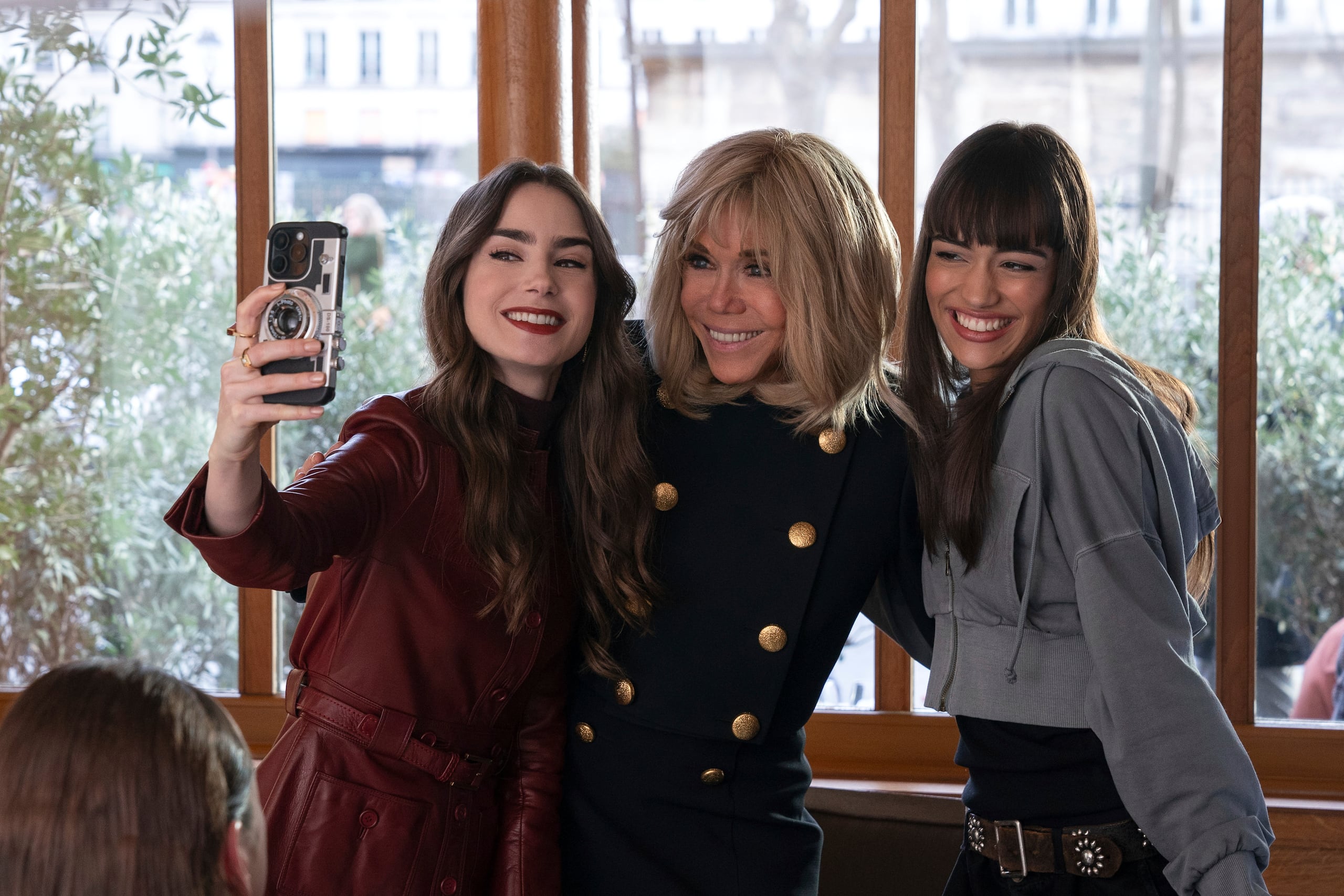 La actriz Lily Collins junto a la primera dama de Francia Brigitte Macron y Thalia Besson durante la filmación de un episodio de la serie.