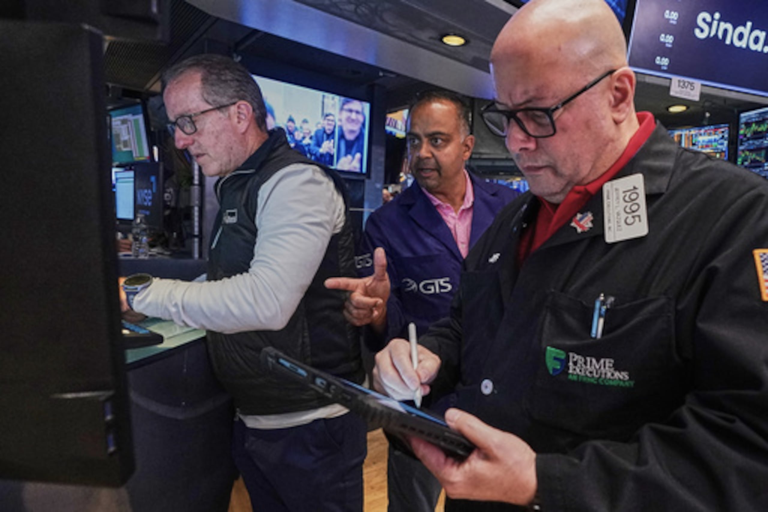 El especialista Glenn Carell, a la izquierda, y Dilip Patel, en el centro, trabajan junto al operador bursátil Jeffrey Vázquez en el parqué de la Bolsa de Nueva York, el viernes 26 de junio de 2026. (Foto AP/Richard Drew)