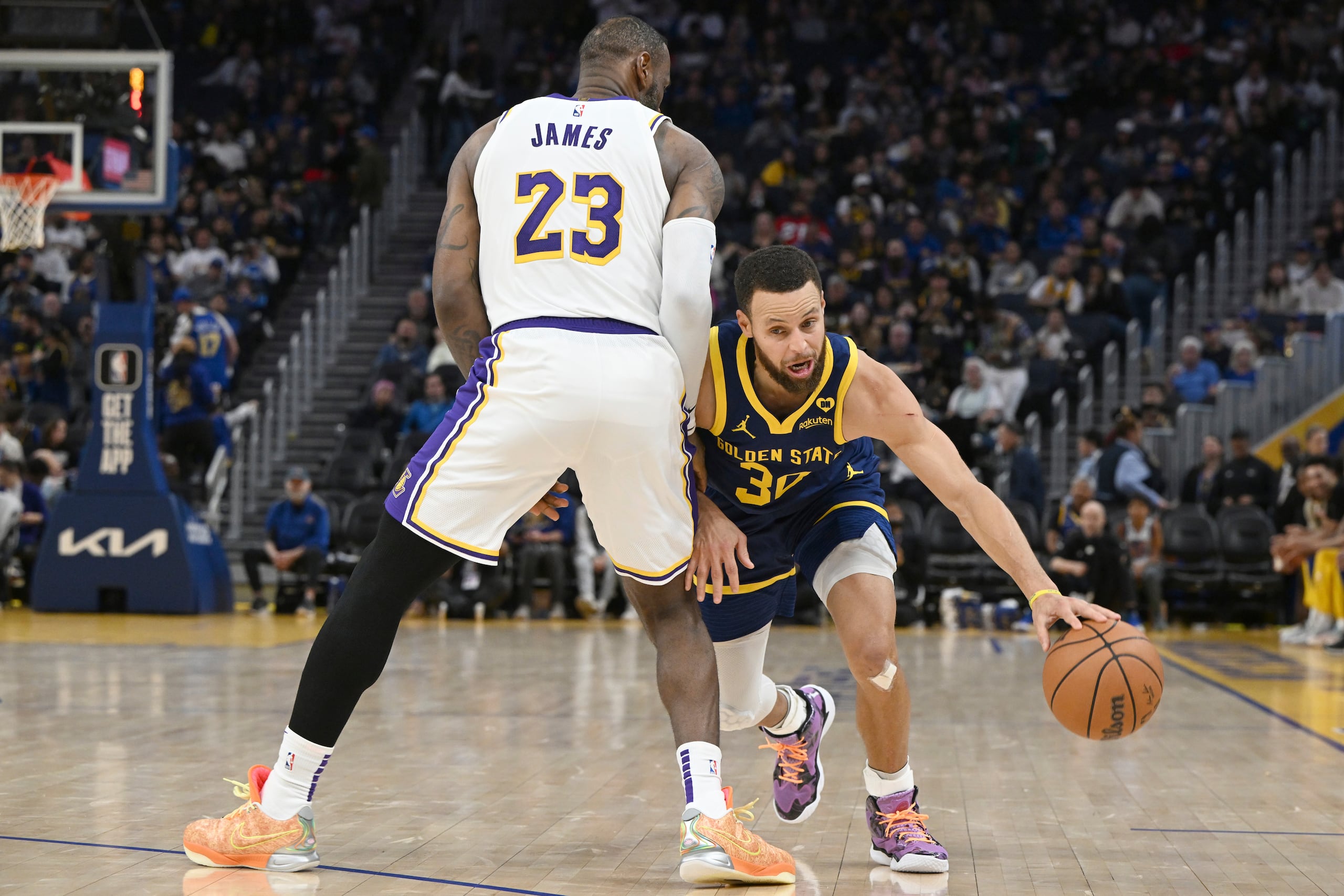 LeBron James busca bloquear el paso de Stephen Curry.