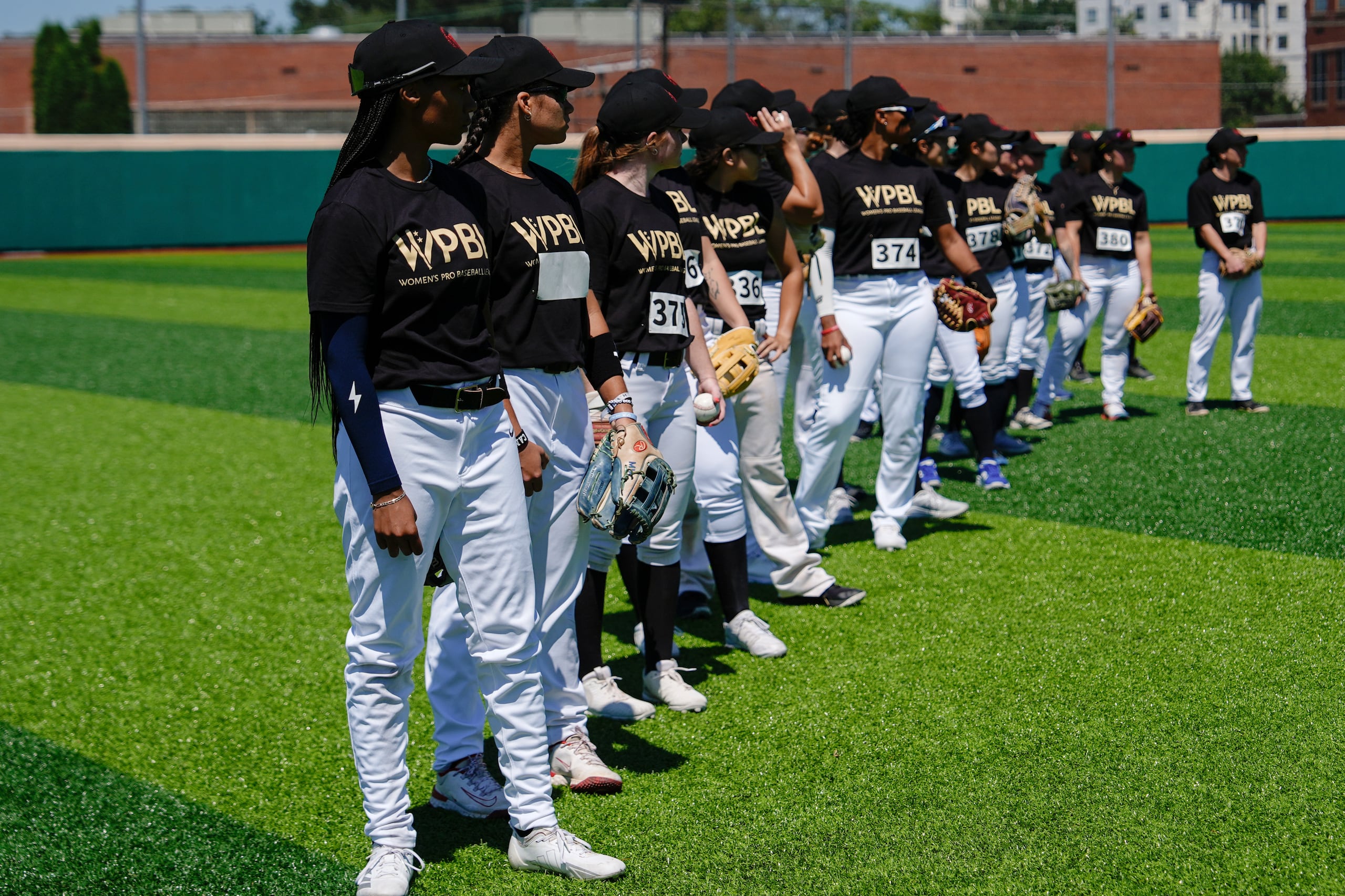 Mo'ne Davis, a la izquierda, y otras jugadoras esperan en fila en el campo durante el primer día de pruebas para la Liga Profesional de Béisbol Femenino.