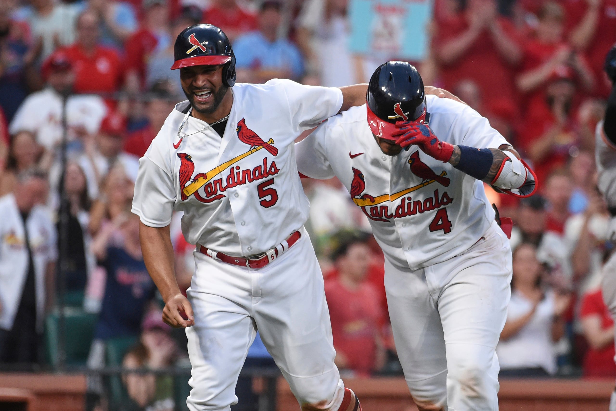 Yadier Molina (4) es recibido en el plato por Albert Pujols luego de pegar un cuadrangular en el partido en que estableció un récord para las Grandes Ligas como compañero de batería del derecho abridor Adam Wainwright en el 2022.