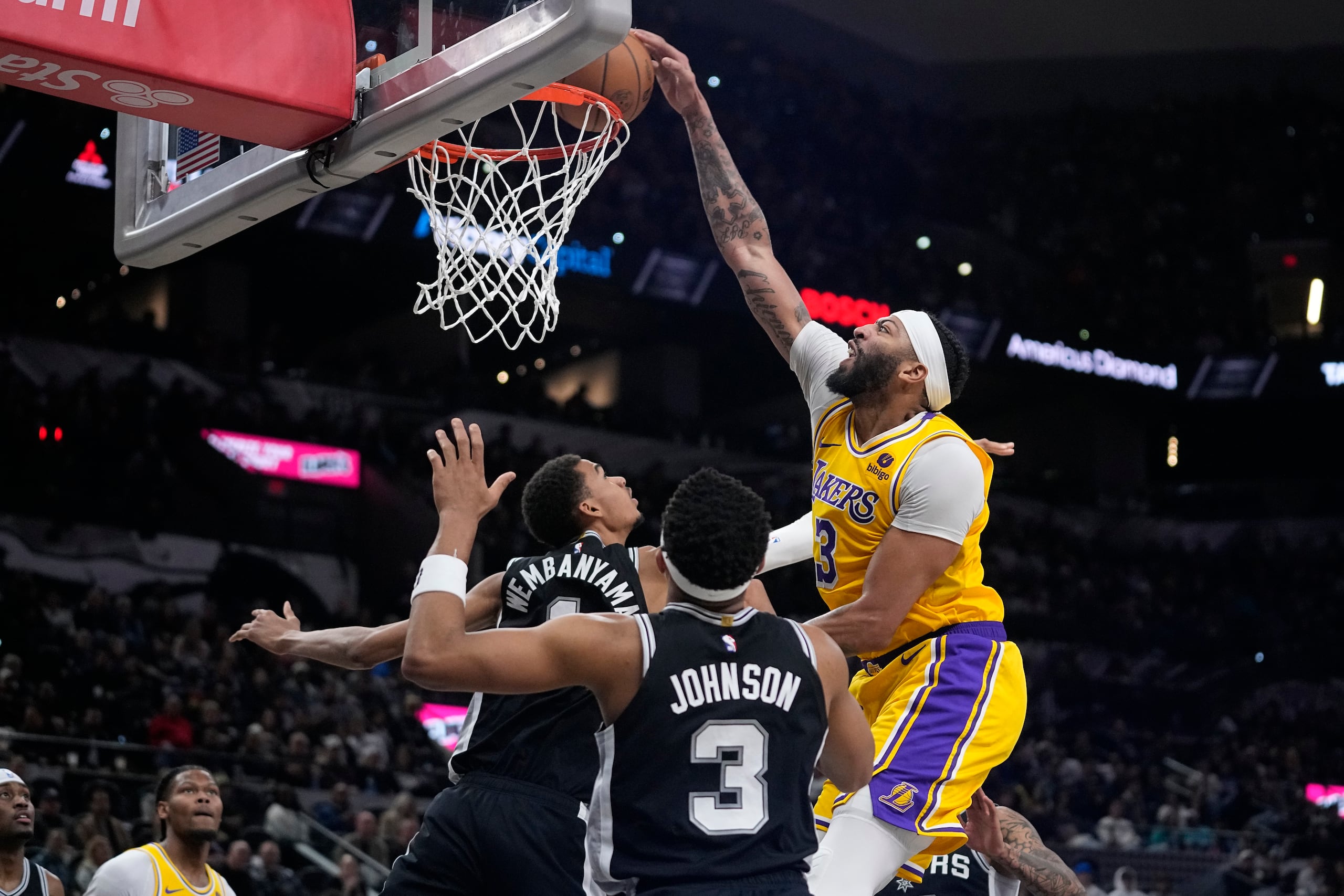 Anthony Davis, de los Lakers de Los Ángeles, donquea frente al francés Victor Wembanyama, de los Spurs de San Antonio.