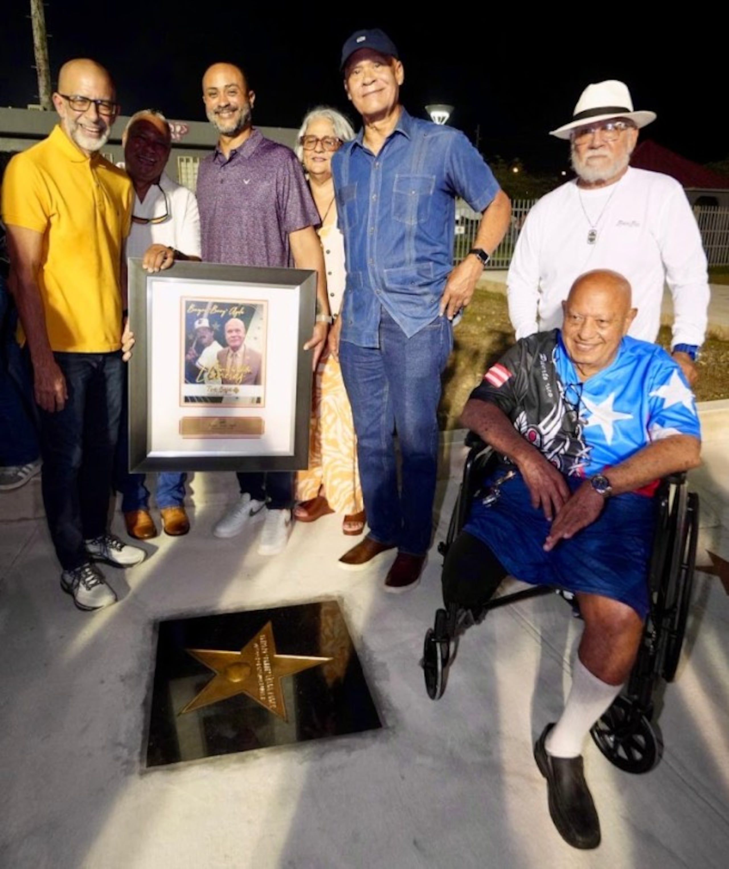 Benigno "Benny" Ayala, al centro, recibe su designación frente a su estrella.