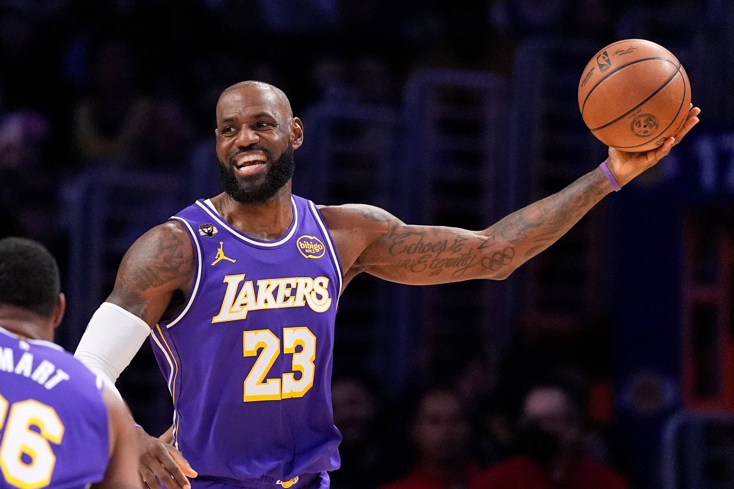 LeBron James, de los Lakers de Los Ángeles, sonríe mientras busca pasar el balón durante la primera mitad del juego de baloncesto de la NBA contra los Mavericks de Dallas, el jueves 12 de febrero de 2026, en Los Ángeles. (AP Foto/Mark J. Terrill)